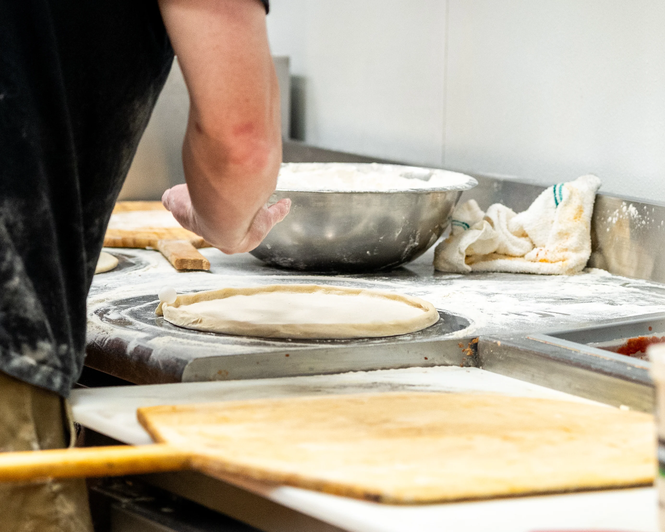 Pizza dough being prepared in a pizzeria kitchen