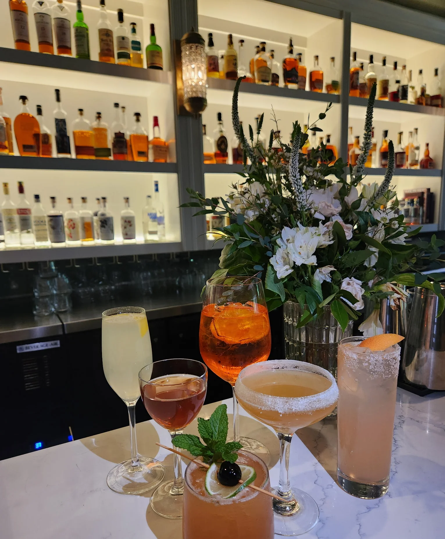 Colorful cocktails displayed on a marble bar counter