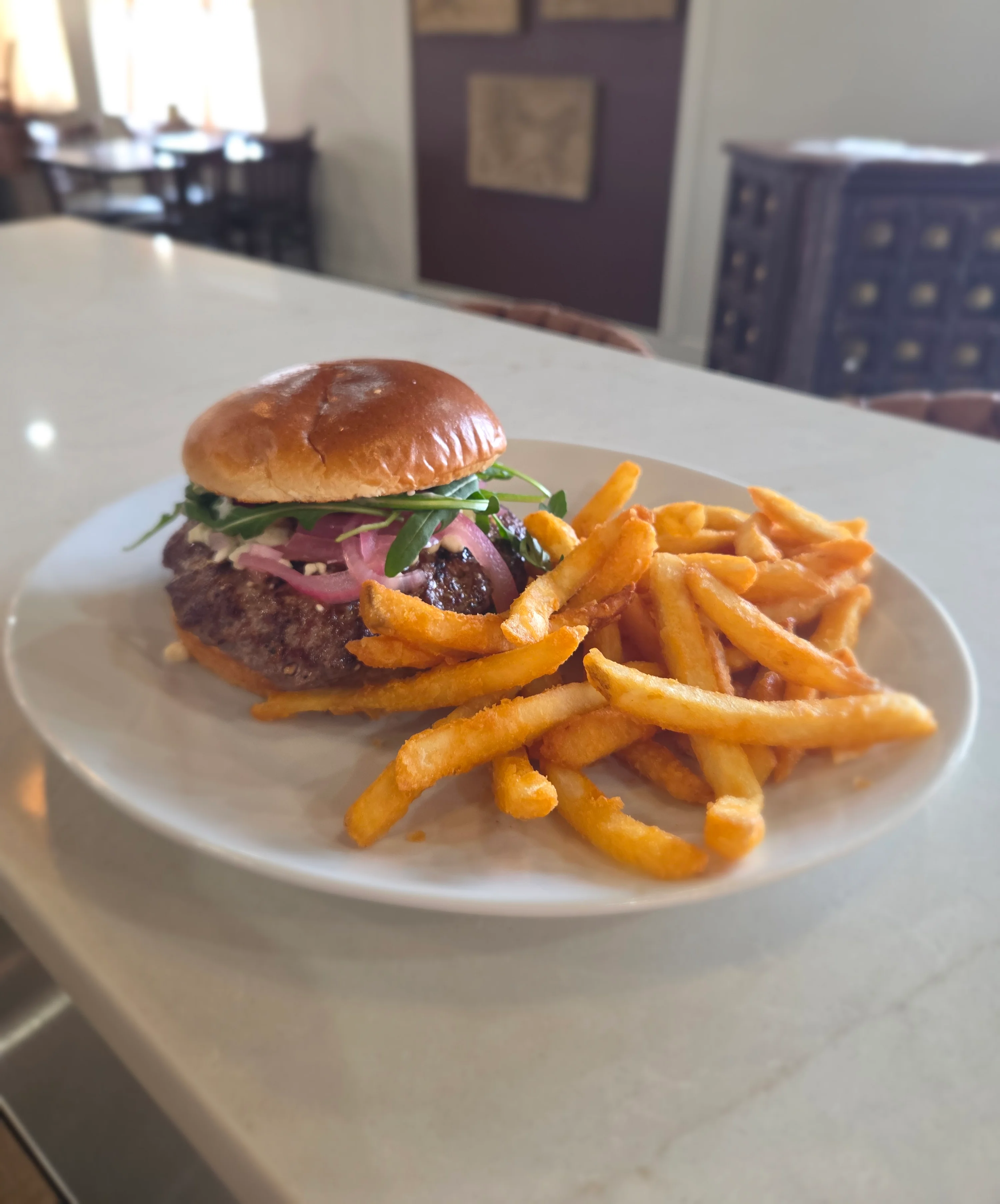 Juicy gourmet burger with fries in a cozy restaurant setting