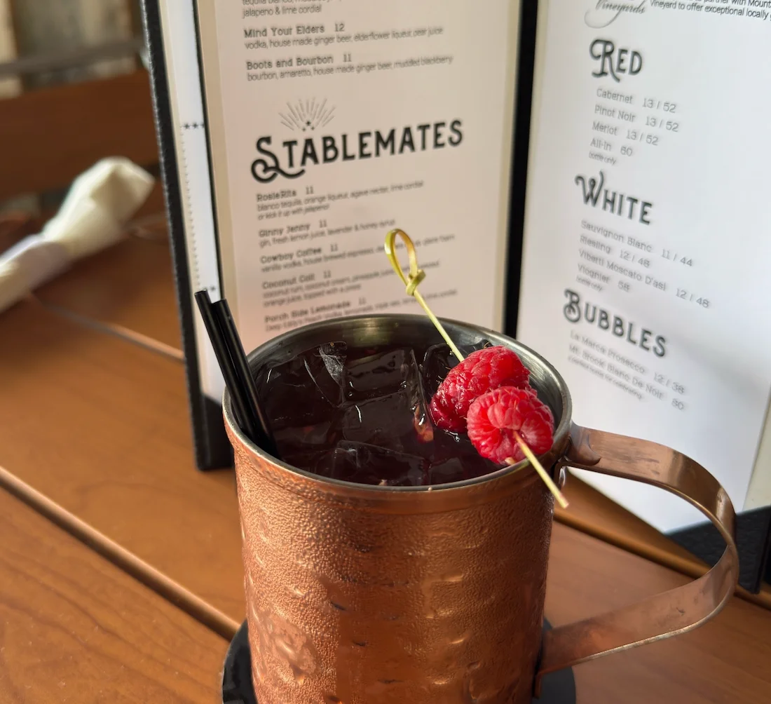 Craft cocktail served in a copper mug with raspberries