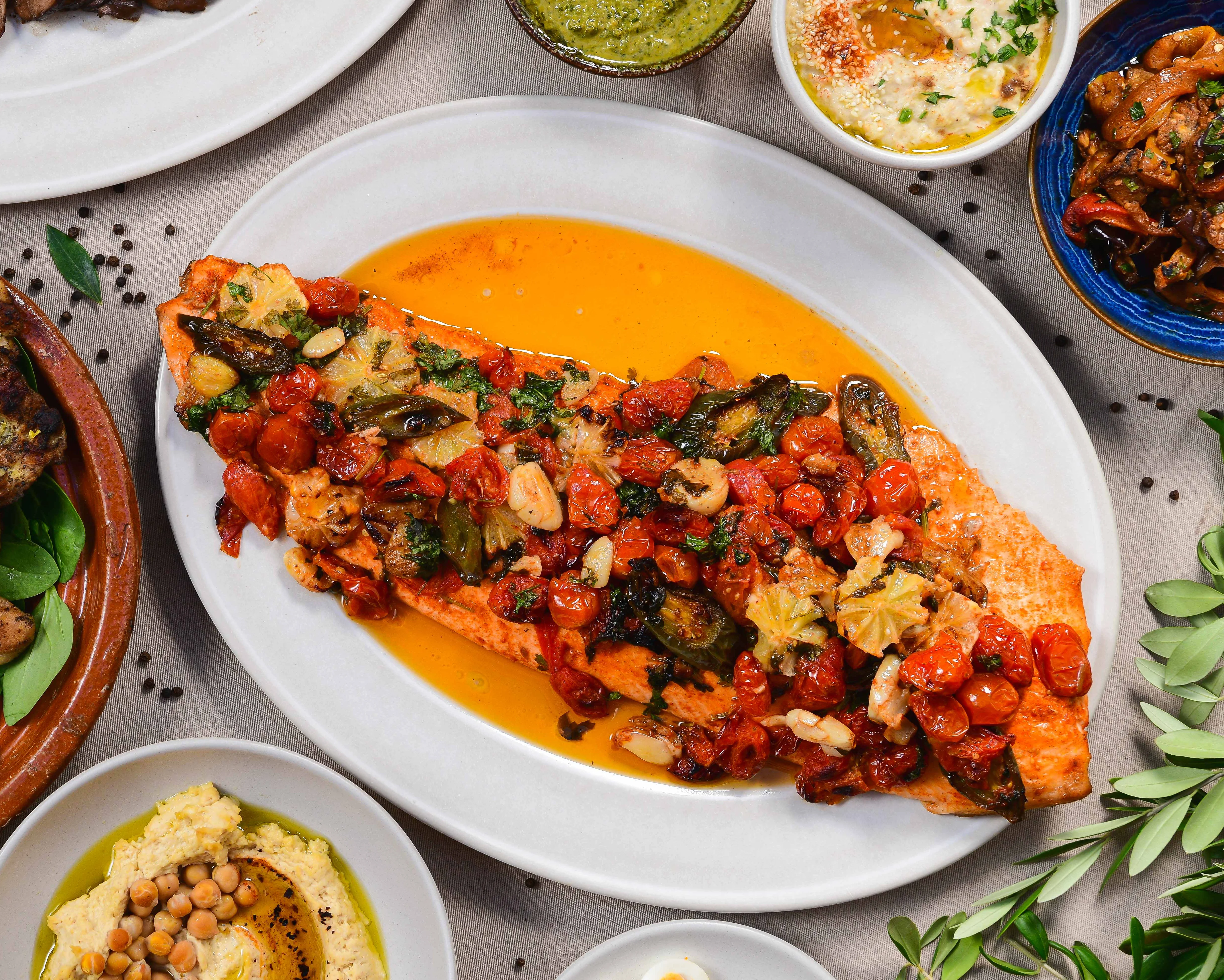 Mediterranean feast featuring grilled salmon and assorted dishes
