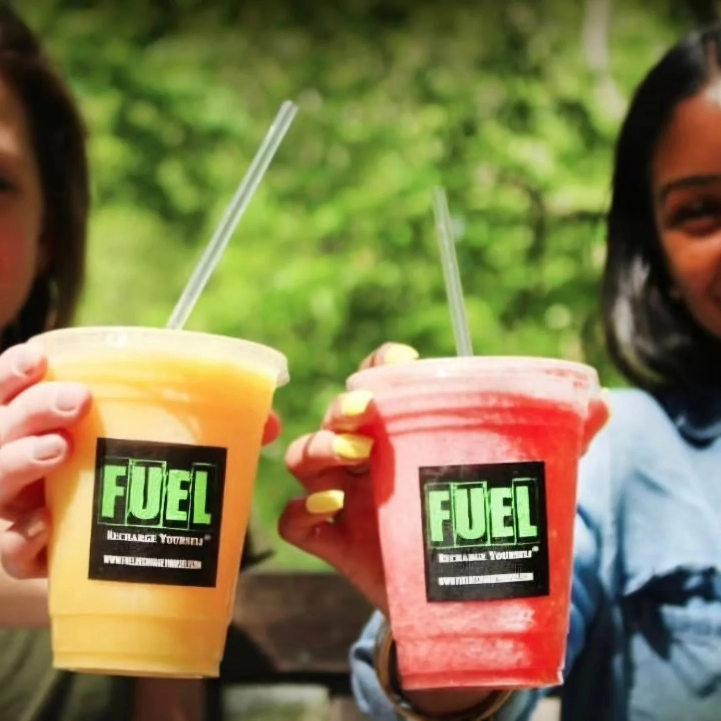 Two colorful smoothies in cups, enjoying a refreshing moment outdoors.