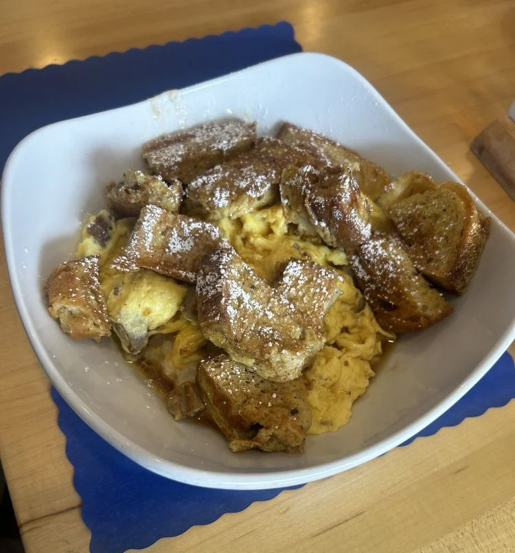 Stack of fluffy pancakes topped with syrup and butter