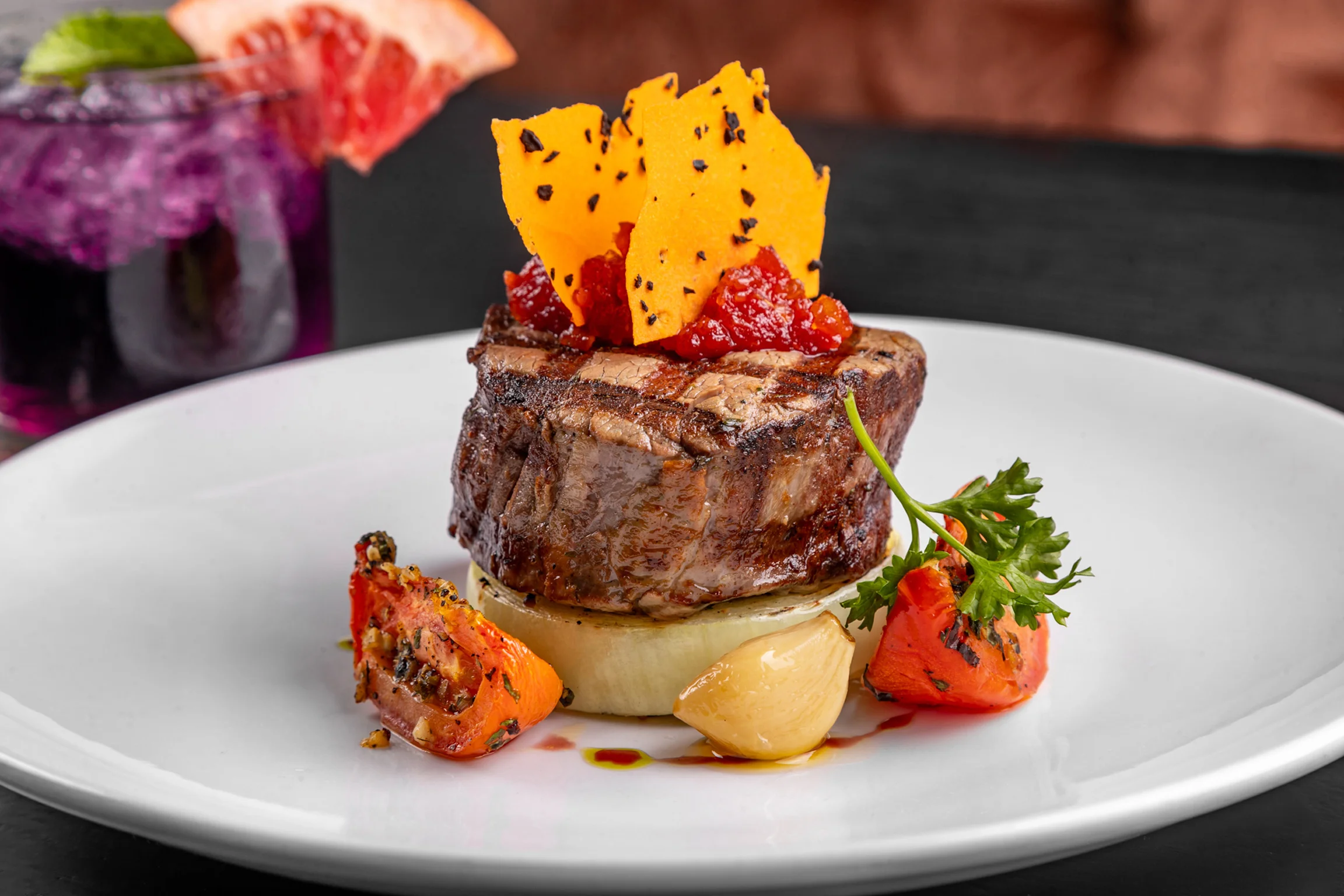 Grilled steak with vibrant garnishes on a white plate