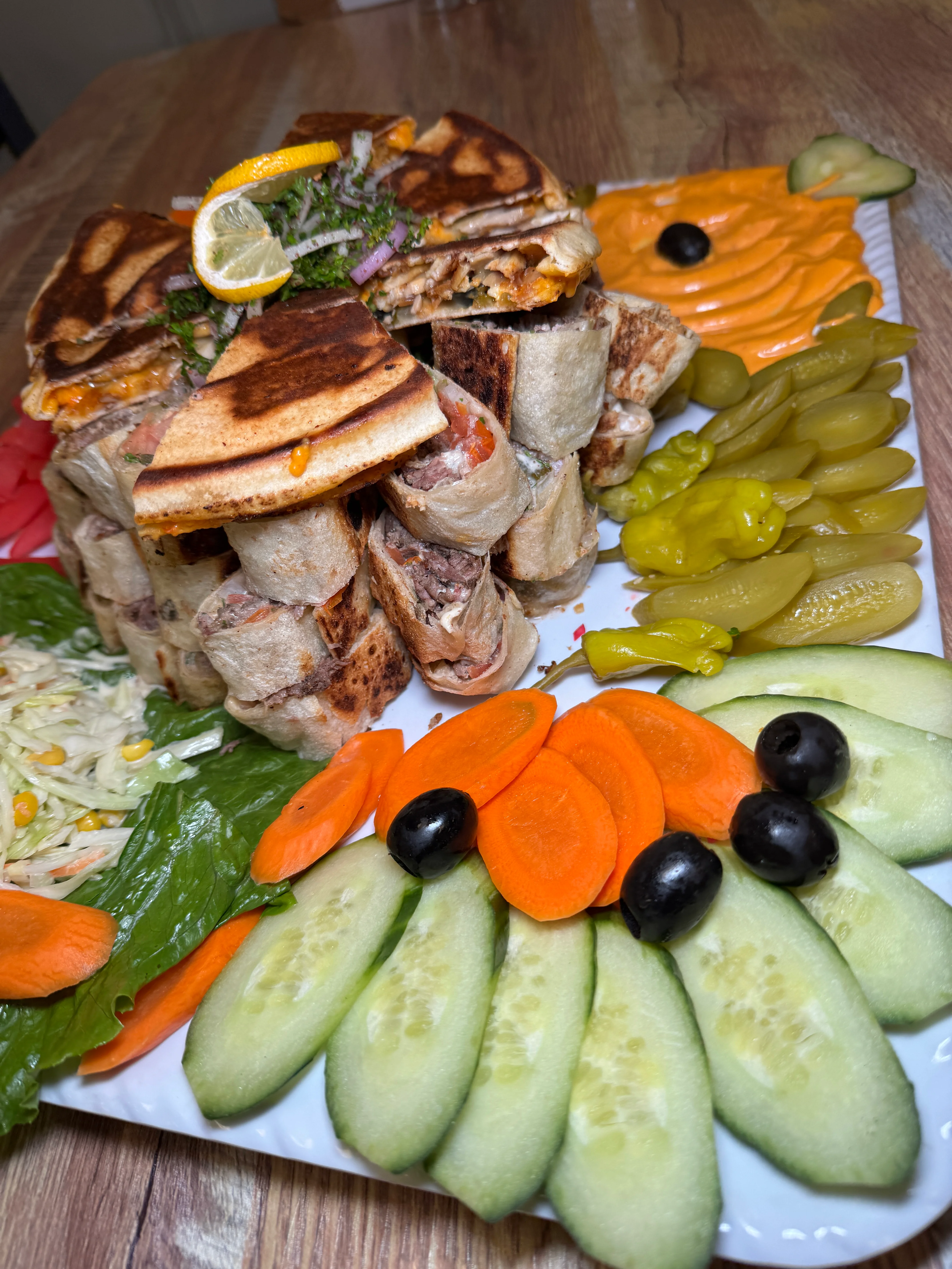 Stacked shawarma wraps with fresh vegetables and sauces