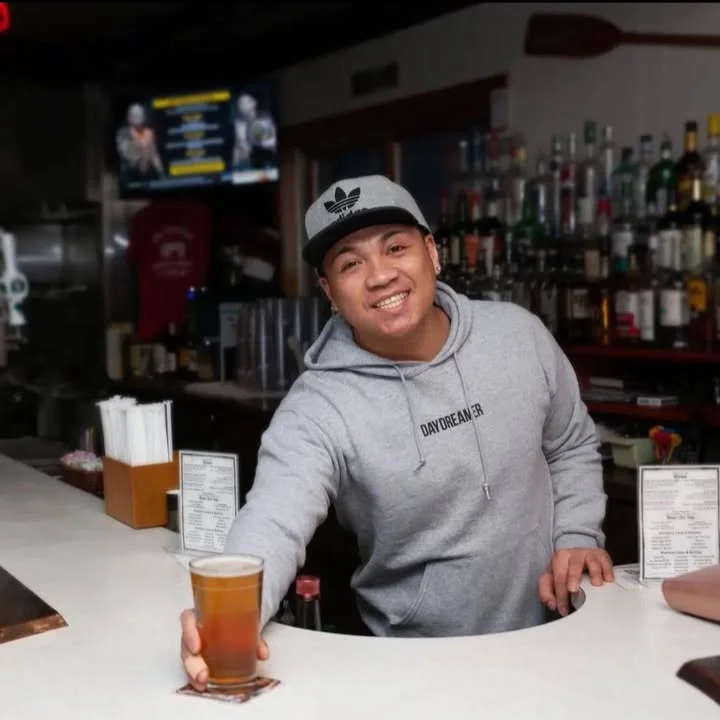 Bartender serving a cold beer at a lively bar