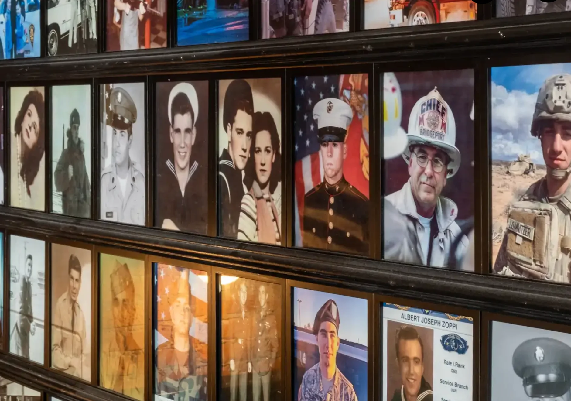 Wall of framed military portraits honoring service members
