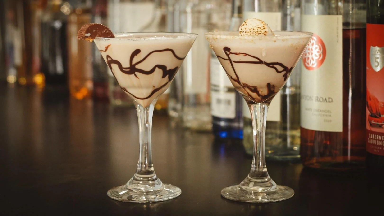 Two martini glasses with olives on a bar counter, celebrating a toast.