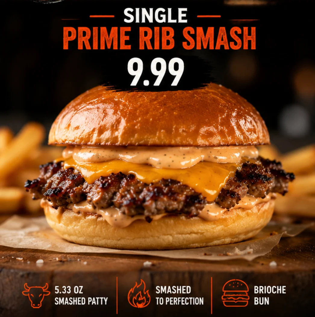 A single prime rib burger with one patty, cheddar cheese, and a creamy sauce on a brioche bun, accompanied by fries.