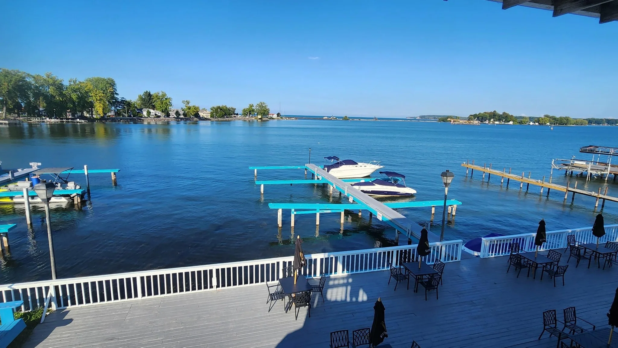 Scenic view of a lake with boats and outdoor dining area by the water