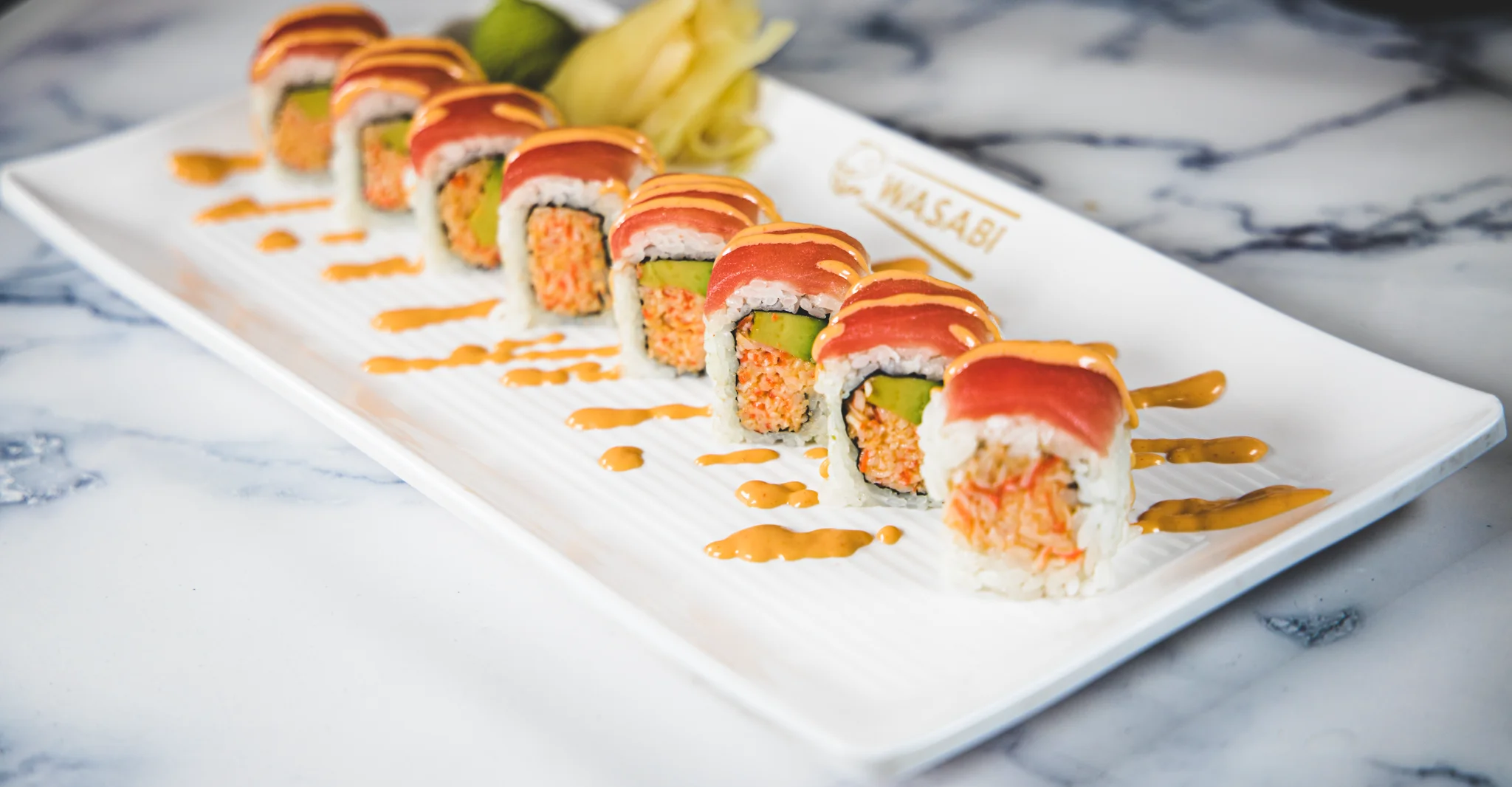 Japanese sushi rolls with spicy sauce and avocado