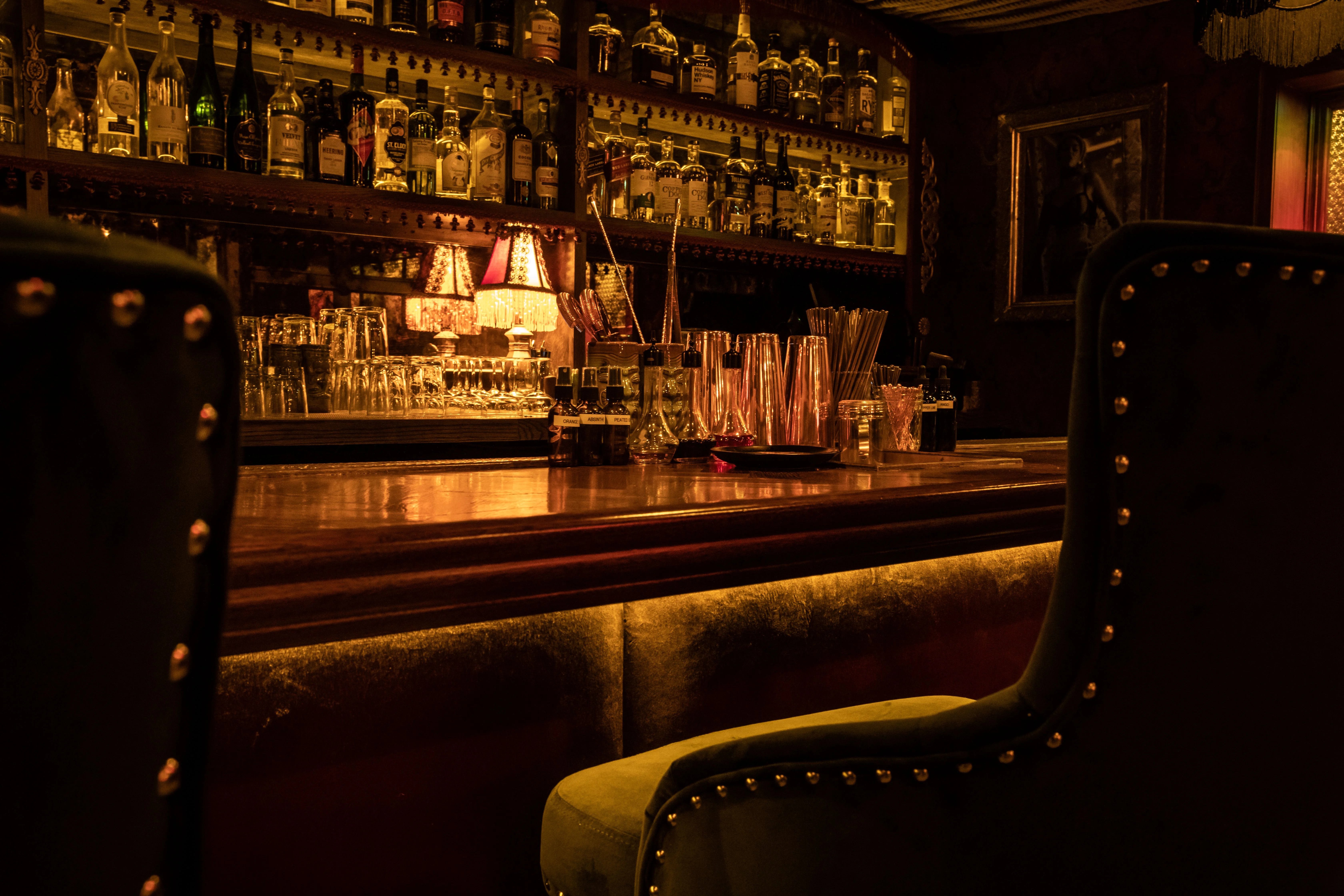 Elegant bar interior with vintage decor and illuminated liquor shelves