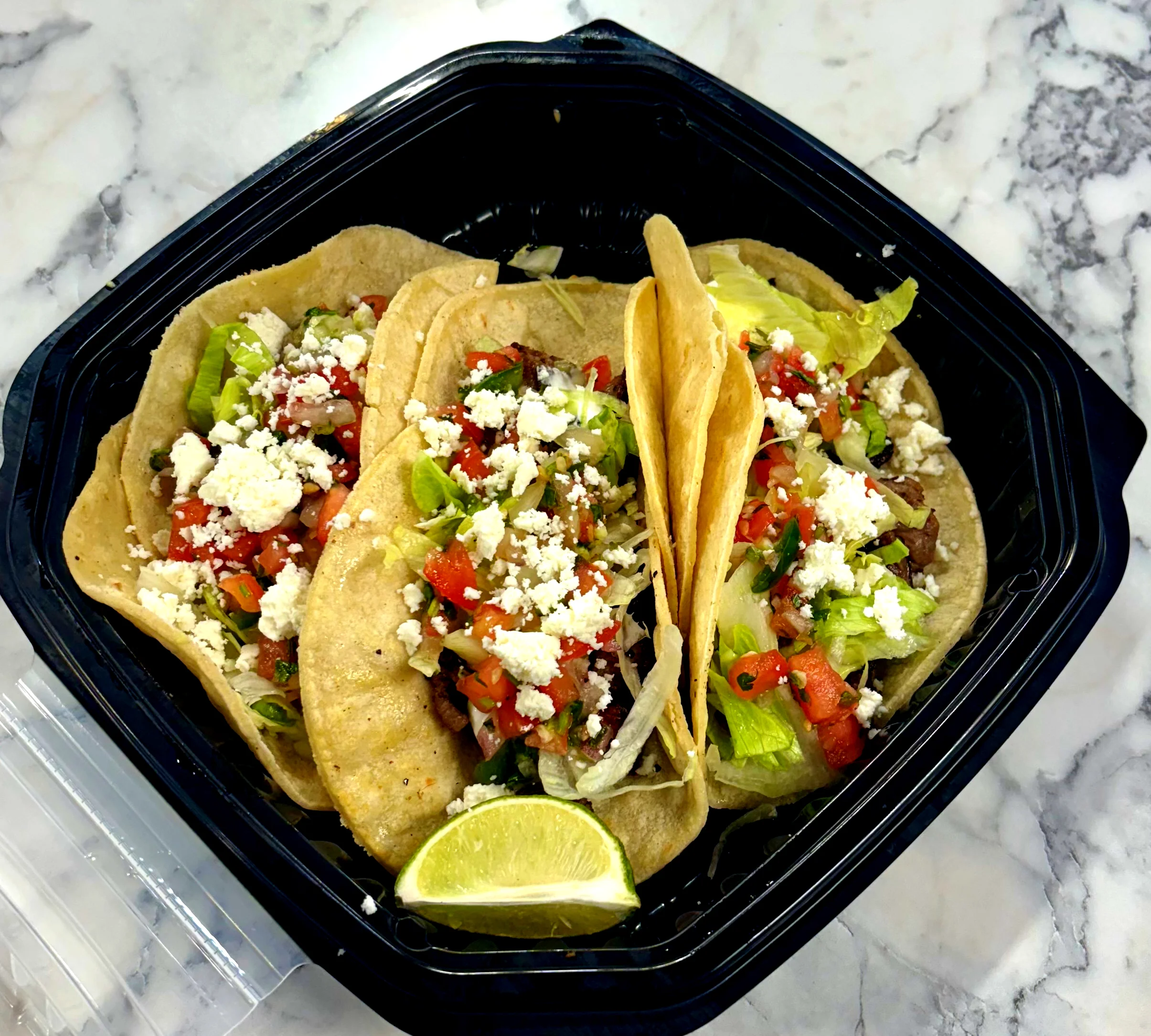 A vibrant plate of assorted tacos with fresh toppings and garnishes.