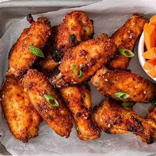 Crispy buffalo chicken wings served with carrots