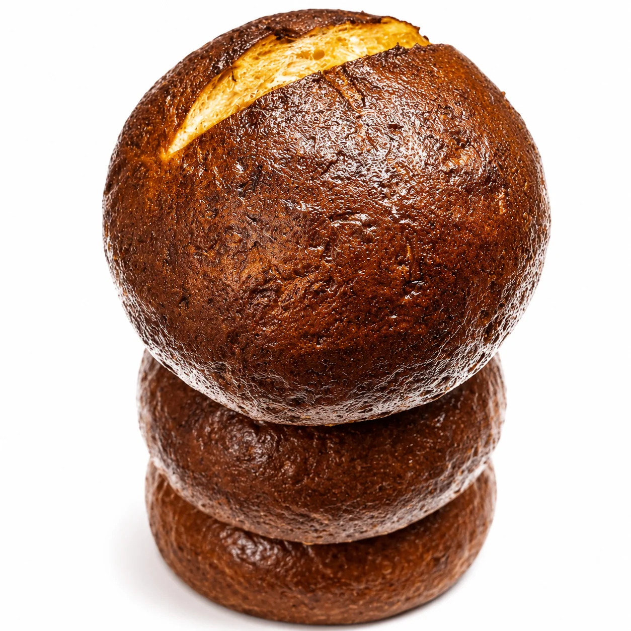 Round, dark bread with a slit on top, showcasing a rustic appearance.