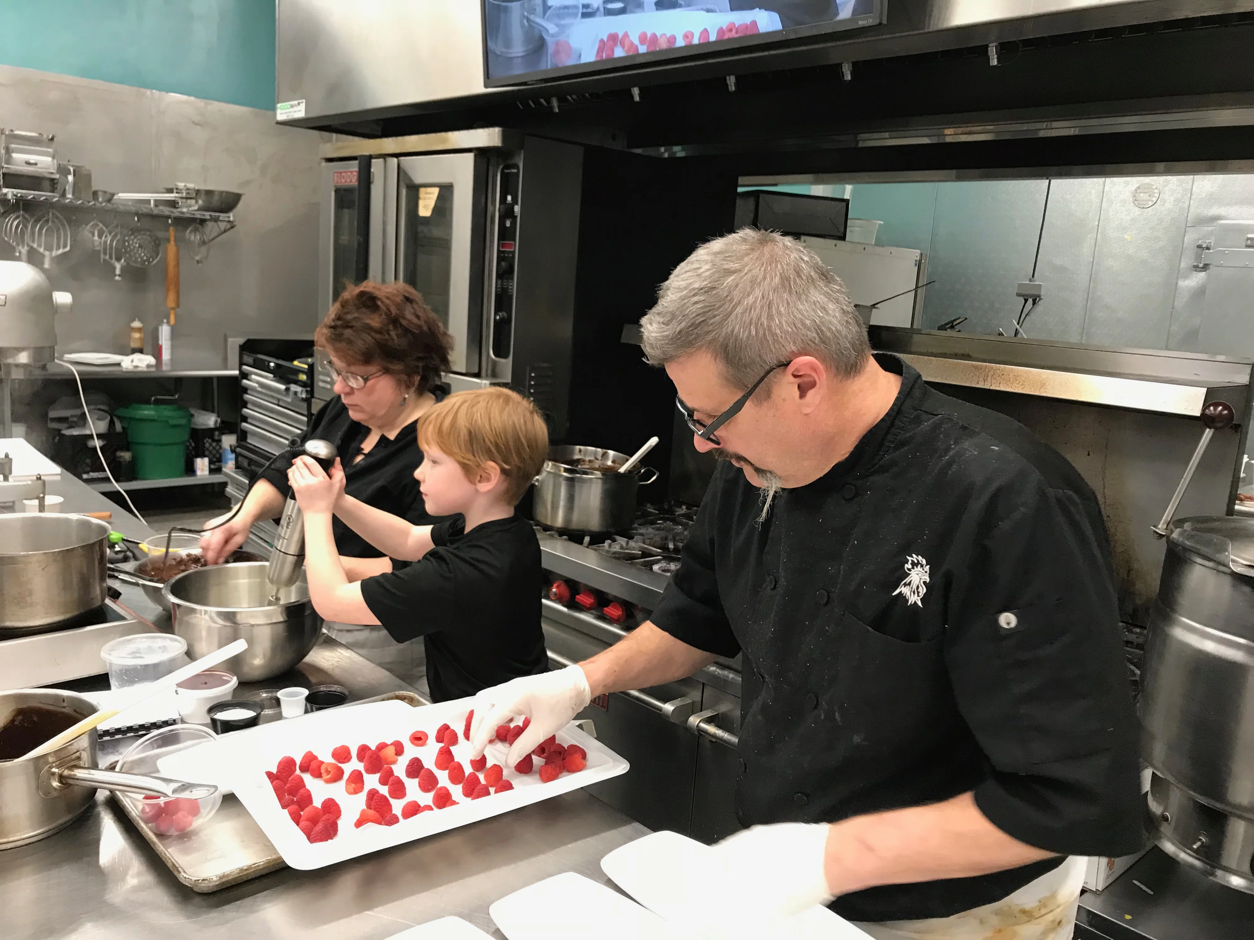 Chefs preparing desserts in a modern kitchen