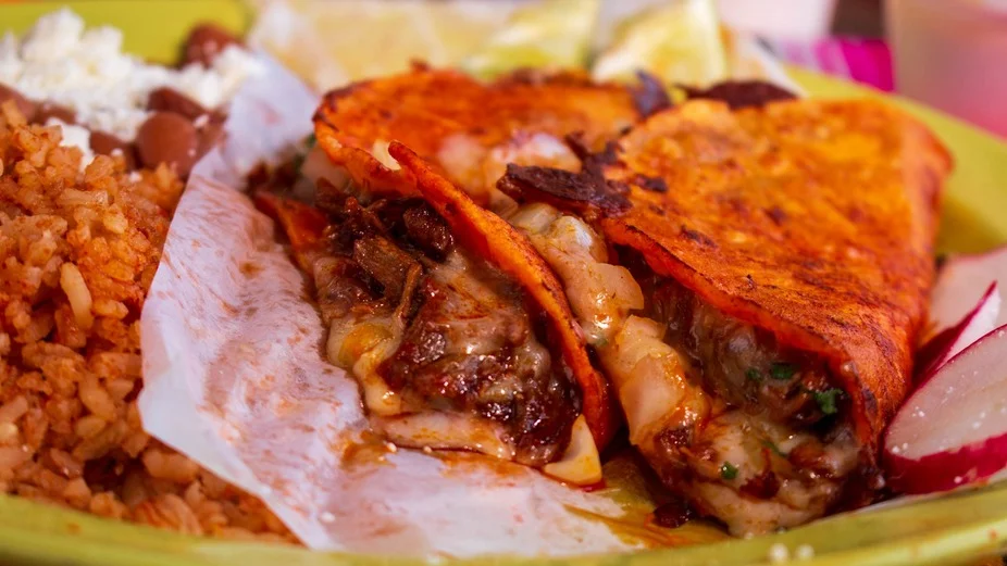 Delicious gourmet burger with fresh toppings on a wooden table.