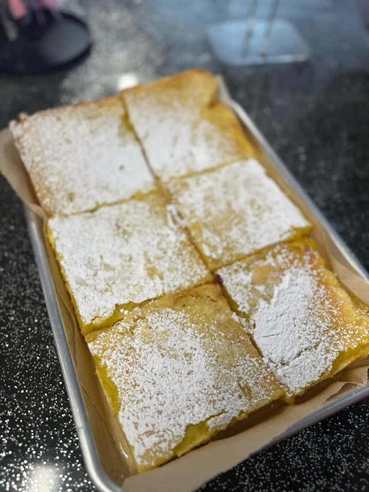 Delicious lemon bars dusted with powdered sugar on a silver tray