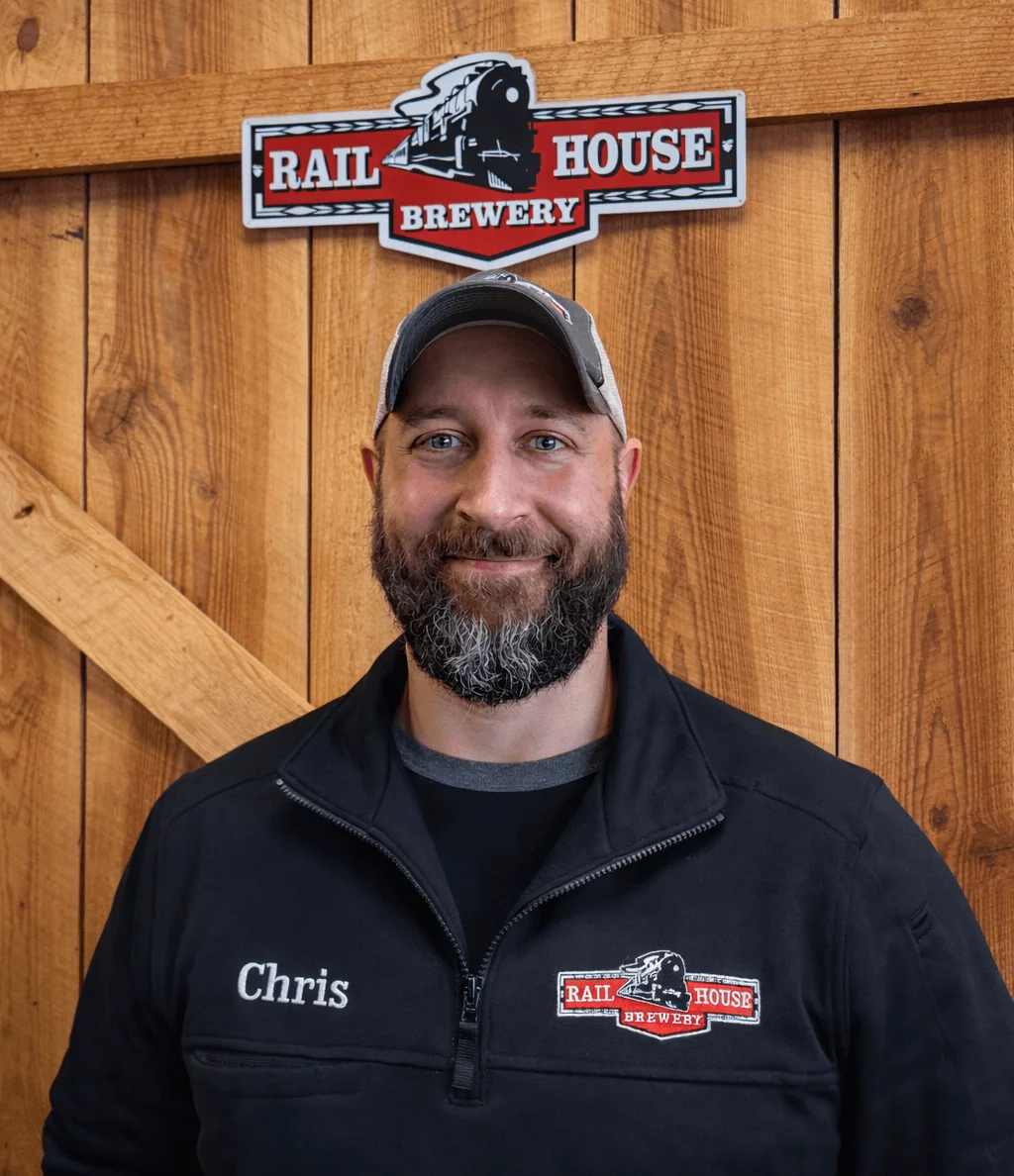 Staff member at Rail House Brewery with wooden backdrop