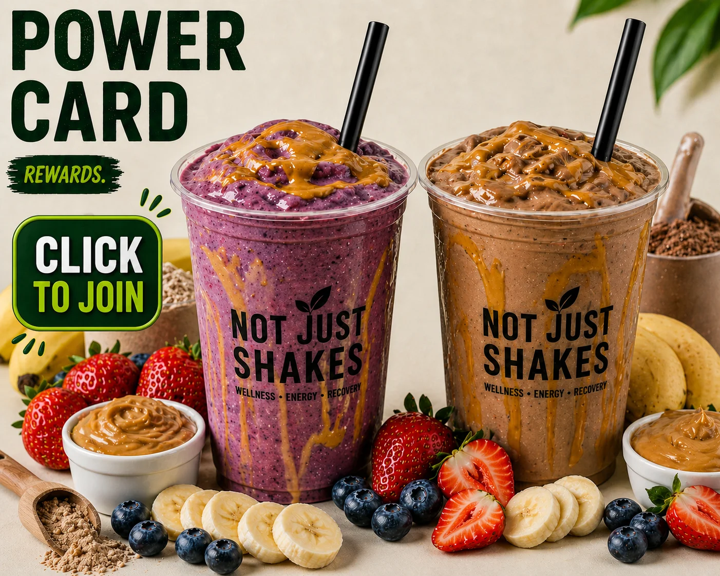 Two colorful smoothie cups topped with peanut butter and surrounded by fresh fruits like strawberries, bananas, and blueberries, along with ingredients for shakes.