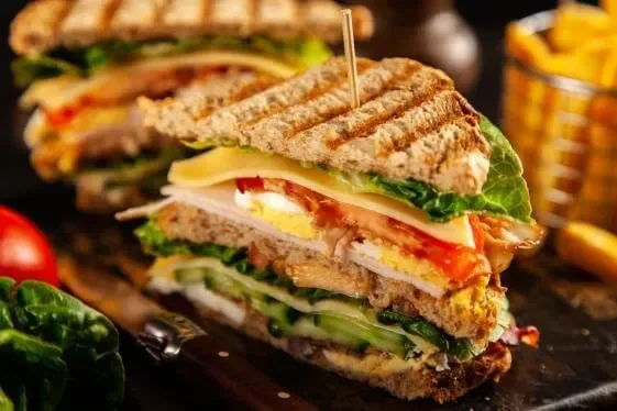 Delicious club sandwich with layers of meats and fresh vegetables