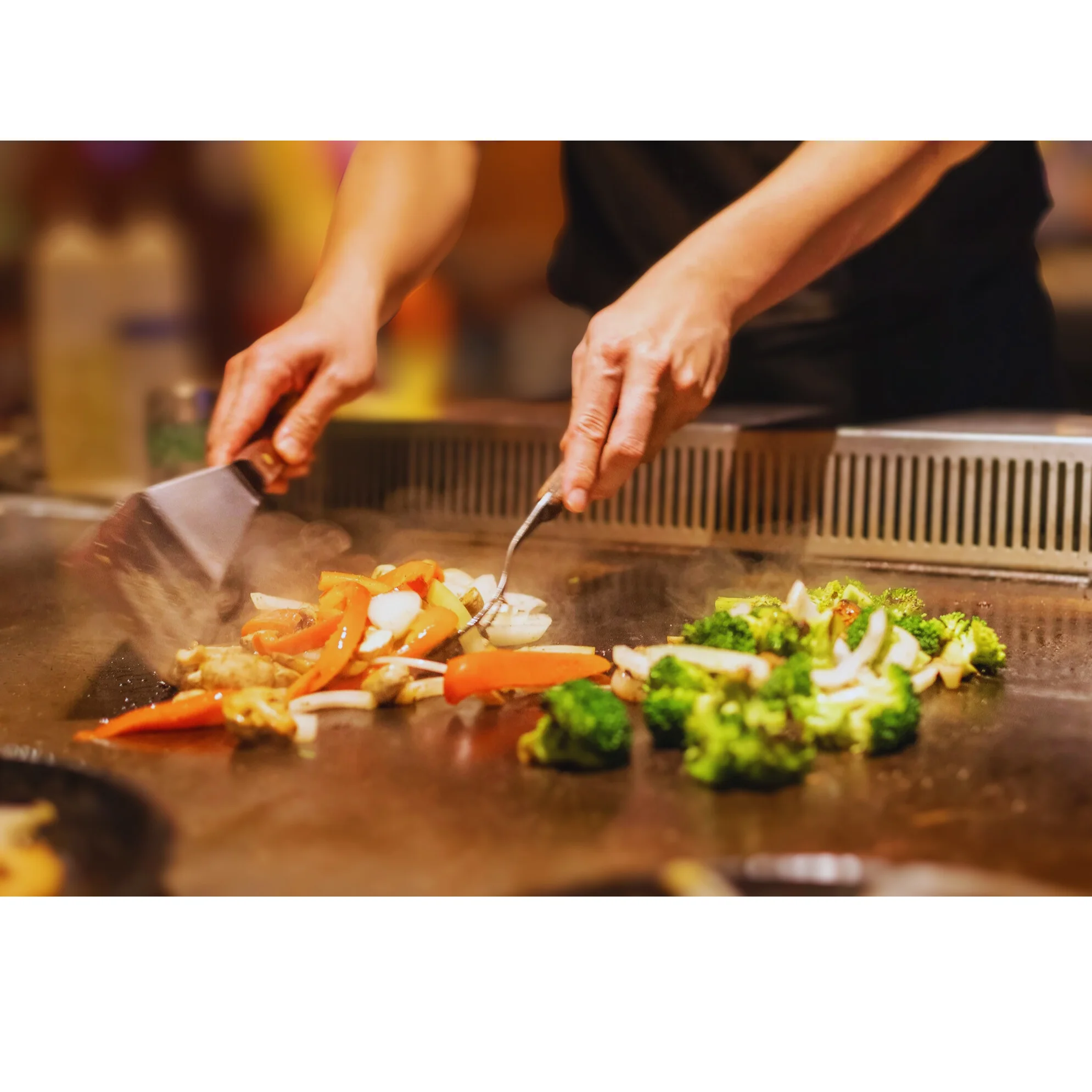Teppanyaki chef grilling fresh vegetables