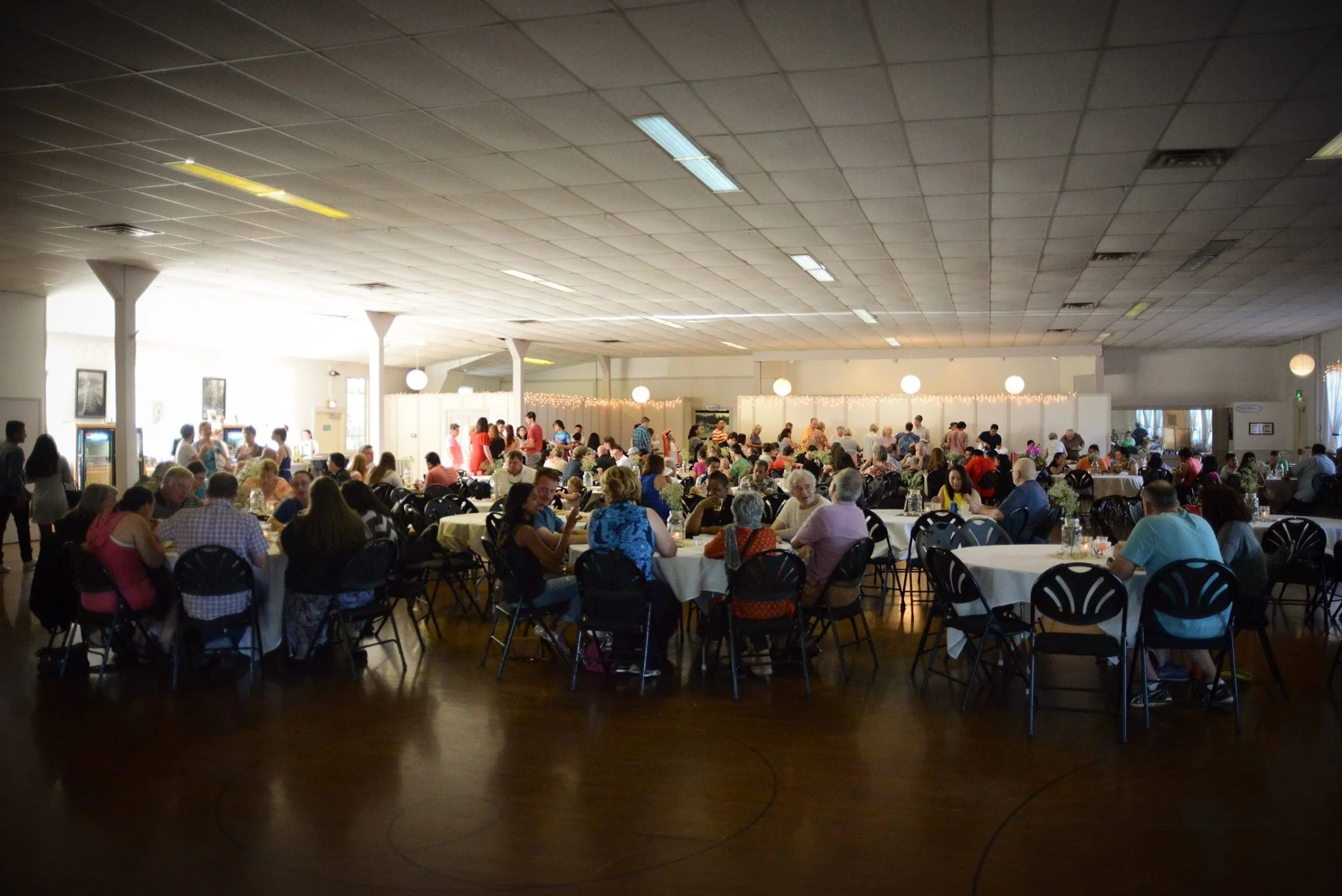 Large dining hall filled with guests enjoying a communal meal