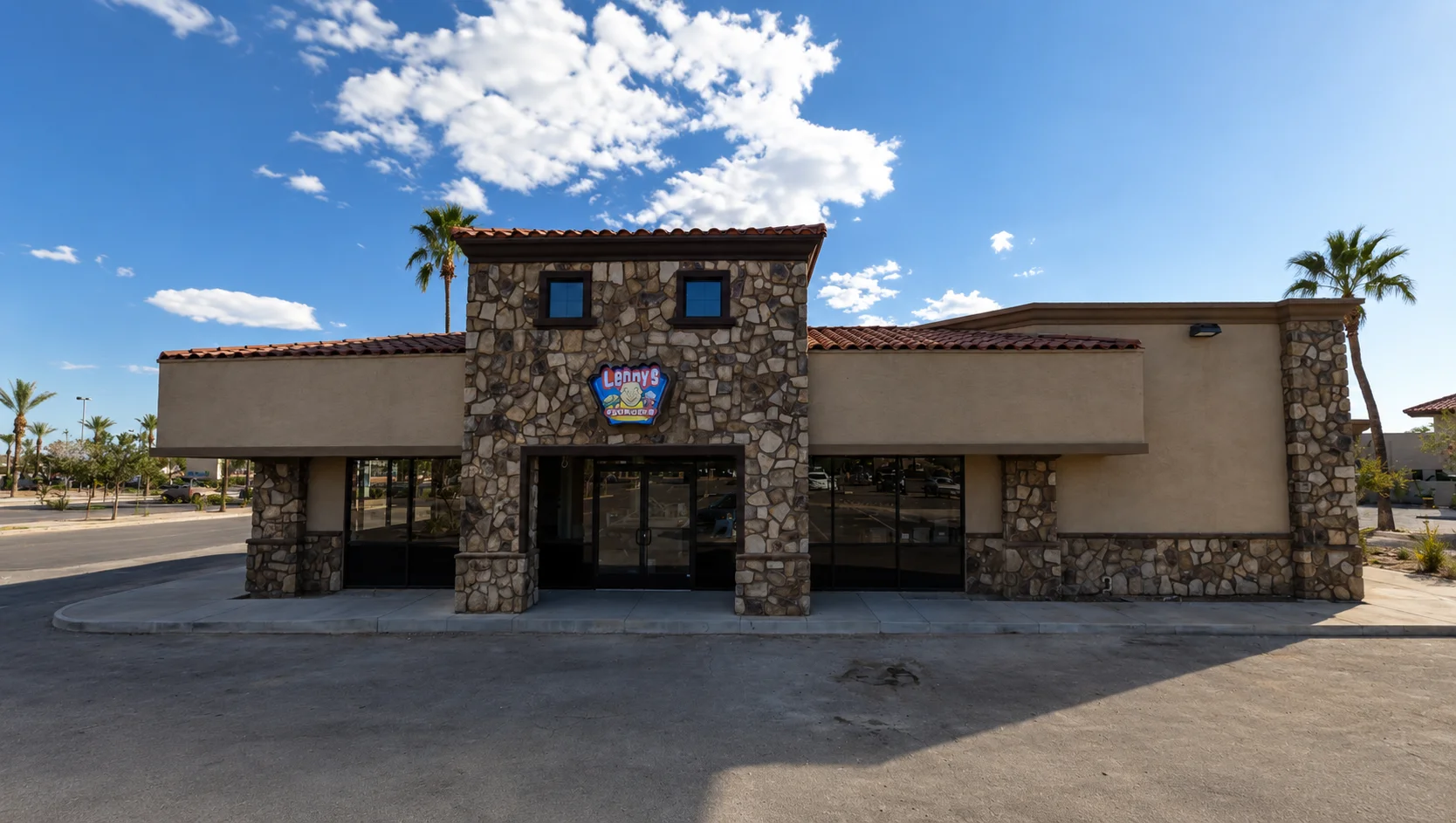 Exterior view of a restaurant with stone facade and palm trees