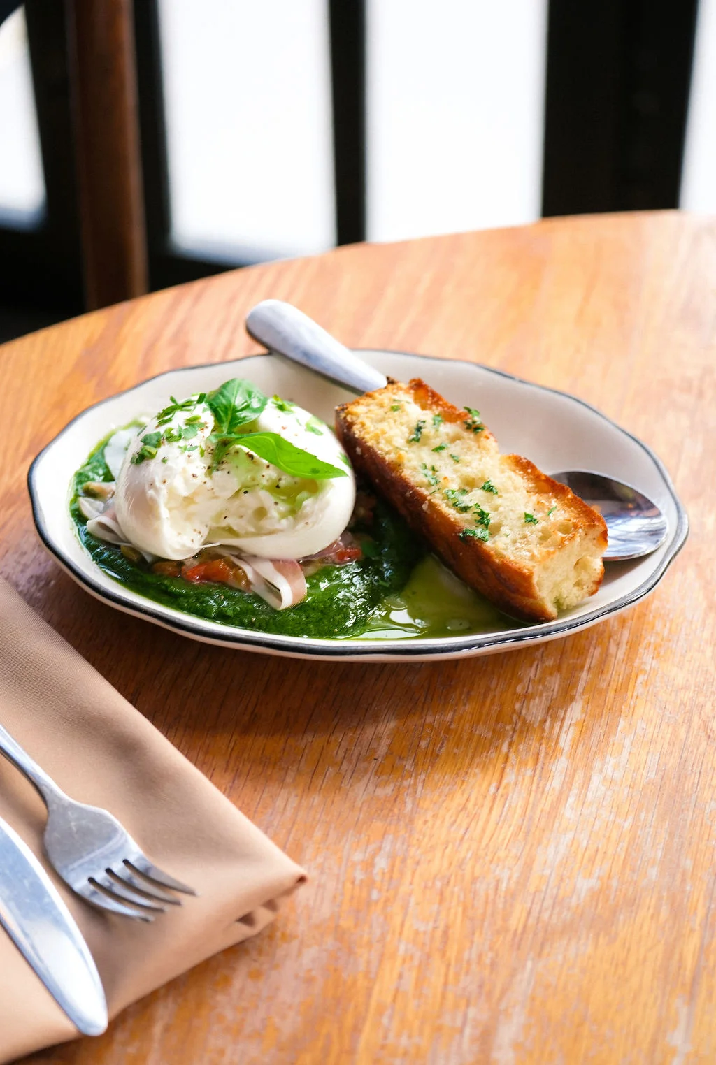 Burrata on pesto with toasted bread, a classic Italian dish