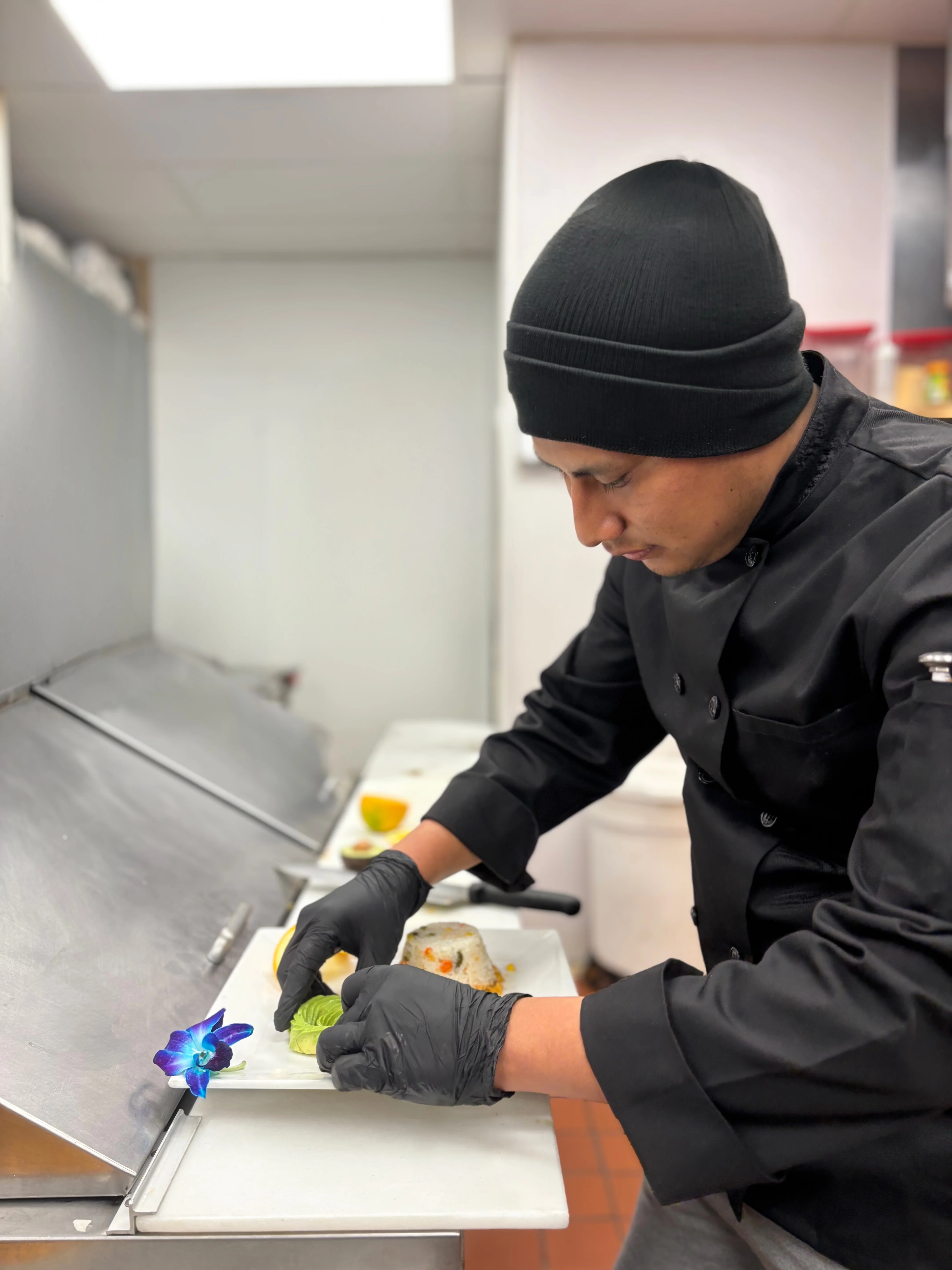 Chef plating sushi with precision in a modern kitchen
