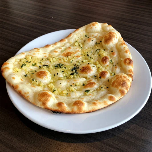 Garlic naan bread served on a white plate