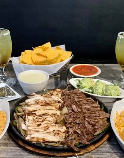 Sizzling fajitas platter with grilled chicken and beef, served with sides