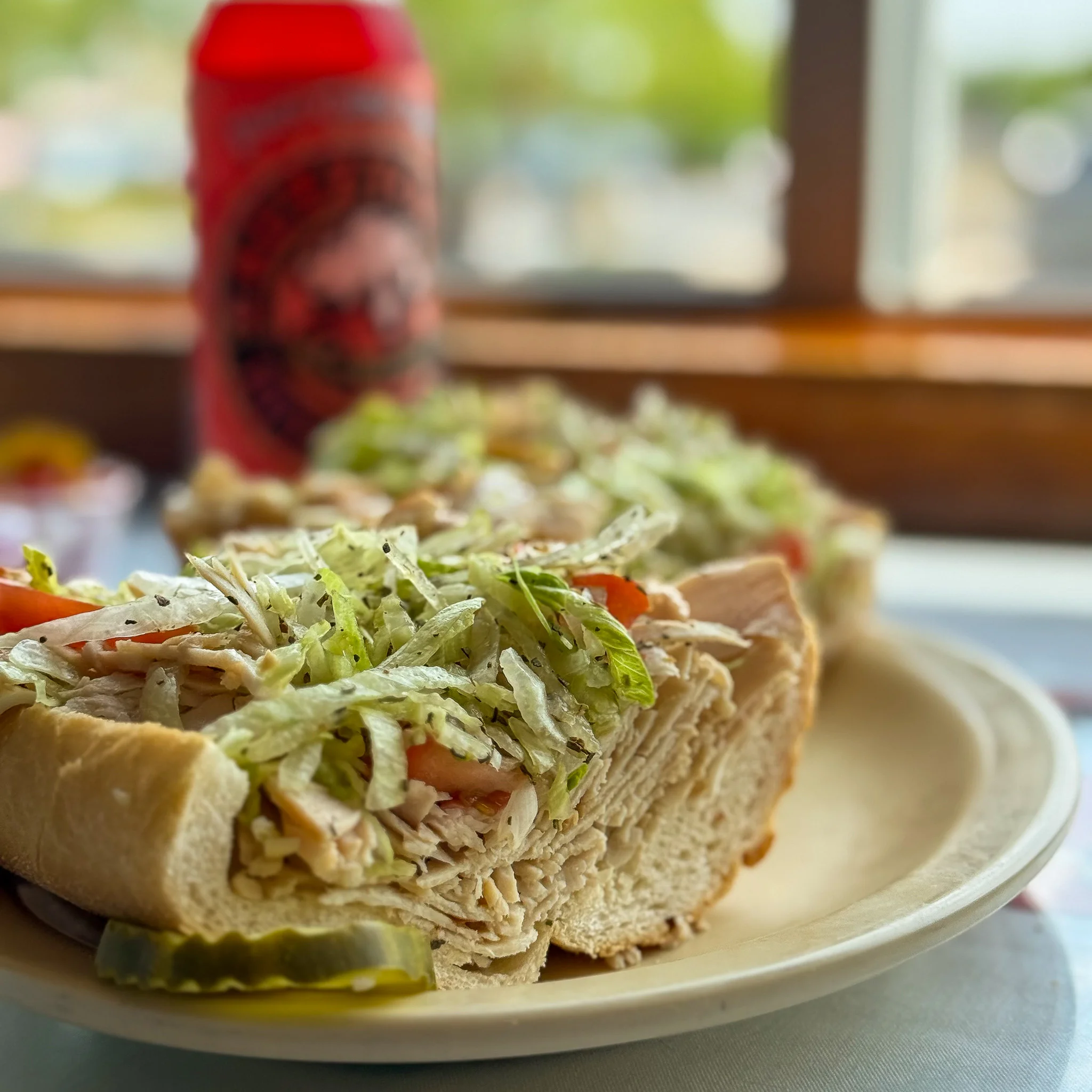 Cold hoagie sandwich with sliced turkey, lettuce, tomato, and cheese.