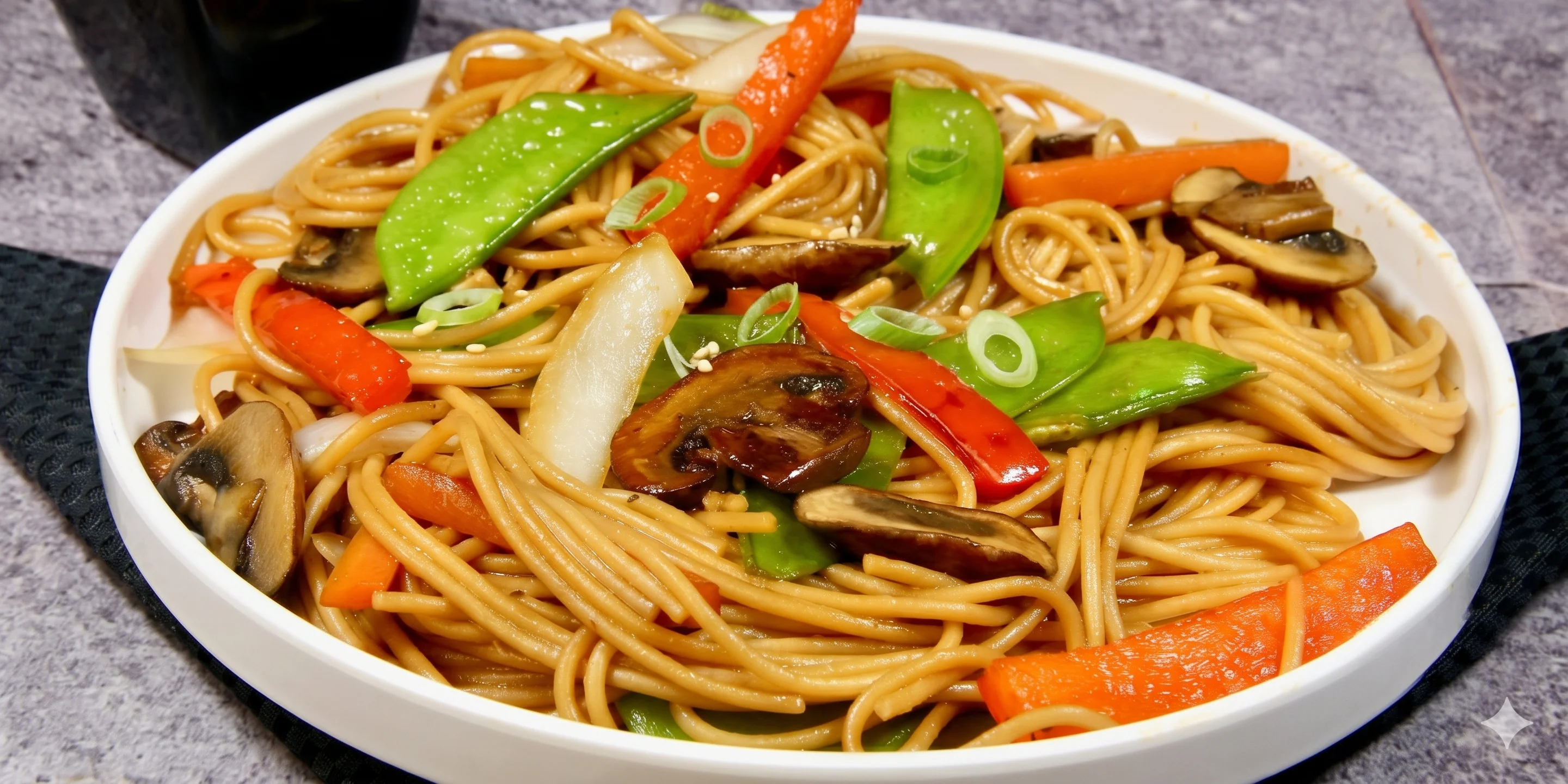 Stir-fried noodles with vegetables in a white bowl.