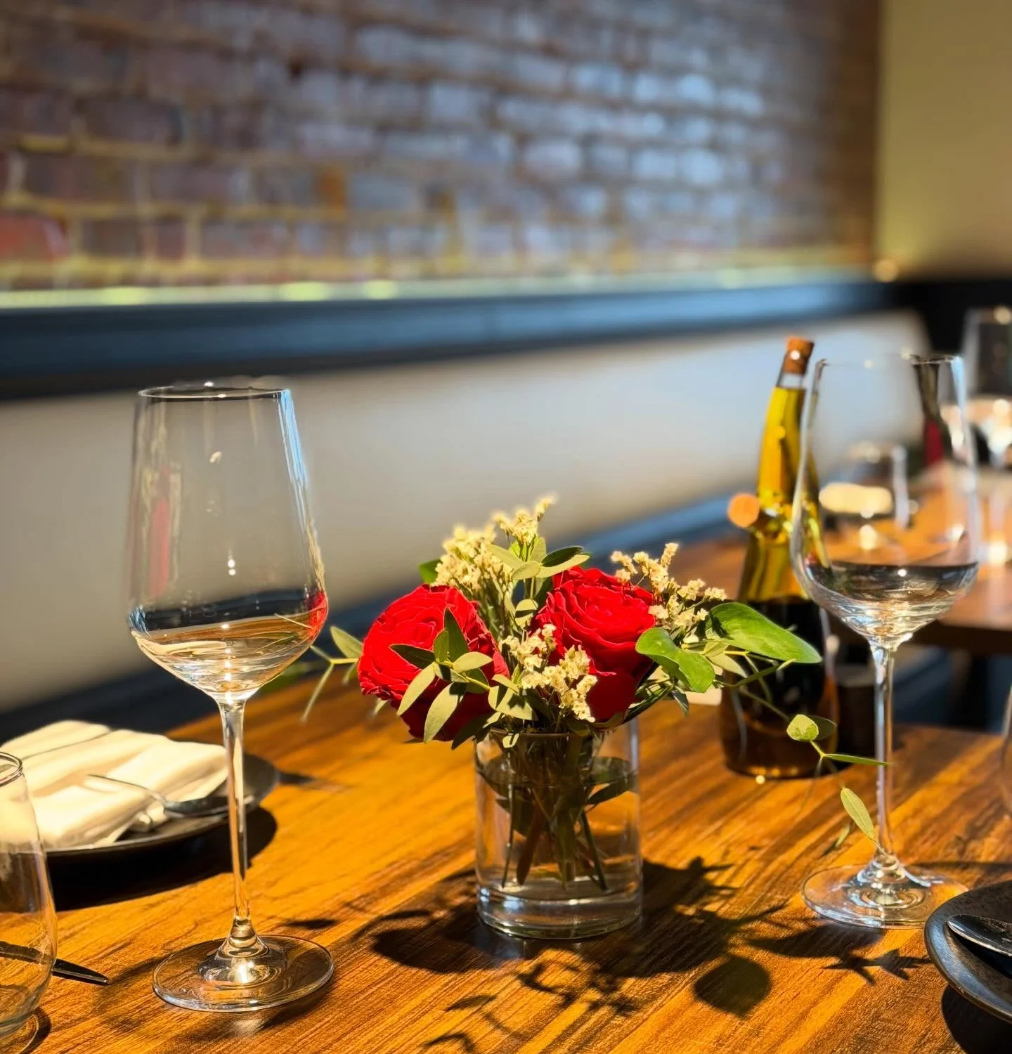 Cozy restaurant table with red roses and elegant glassware