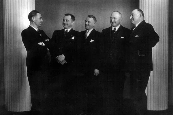 Group of five men in formal attire posing together