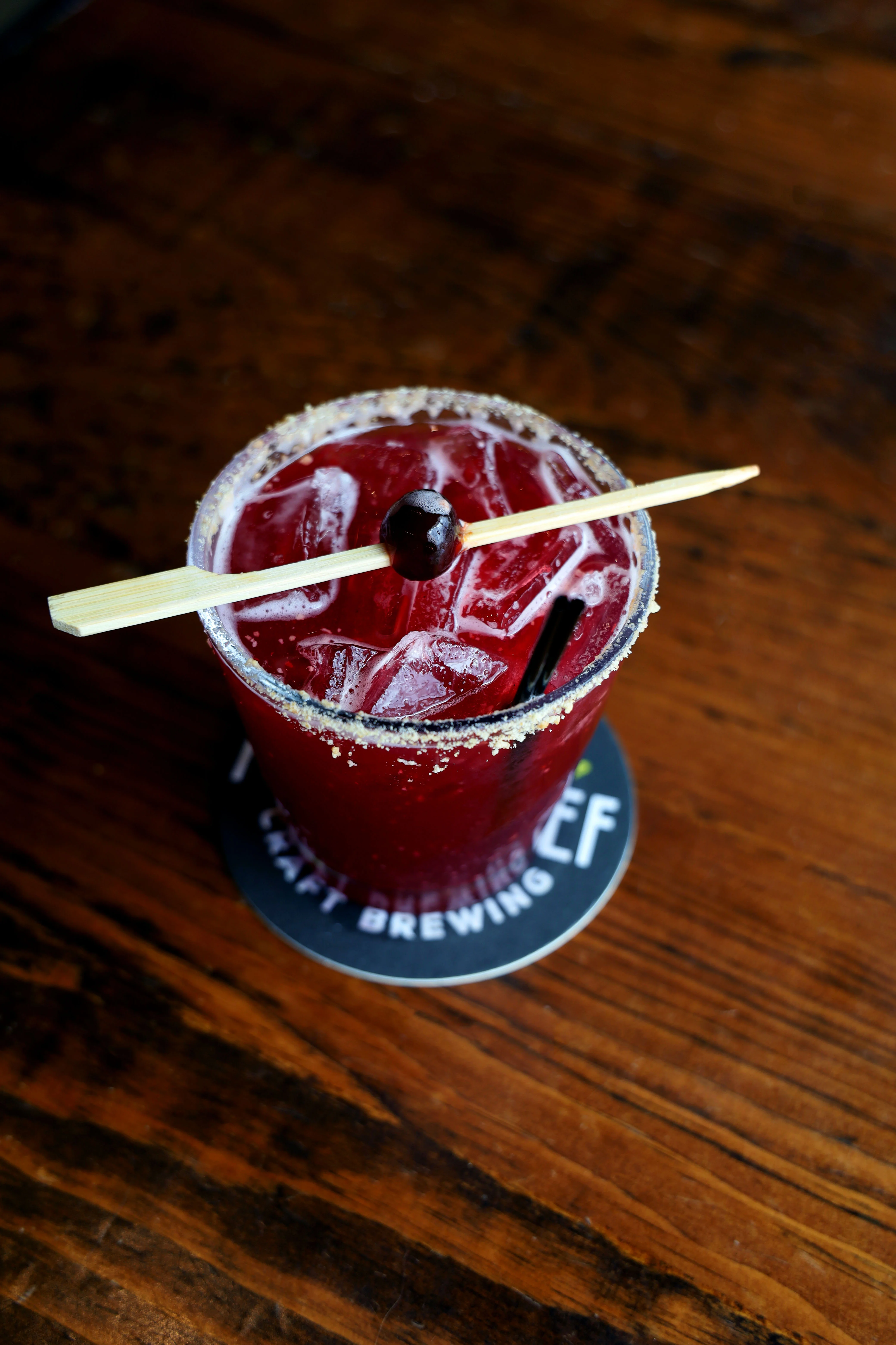 Refreshing cocktail with ice and garnish on a wooden table