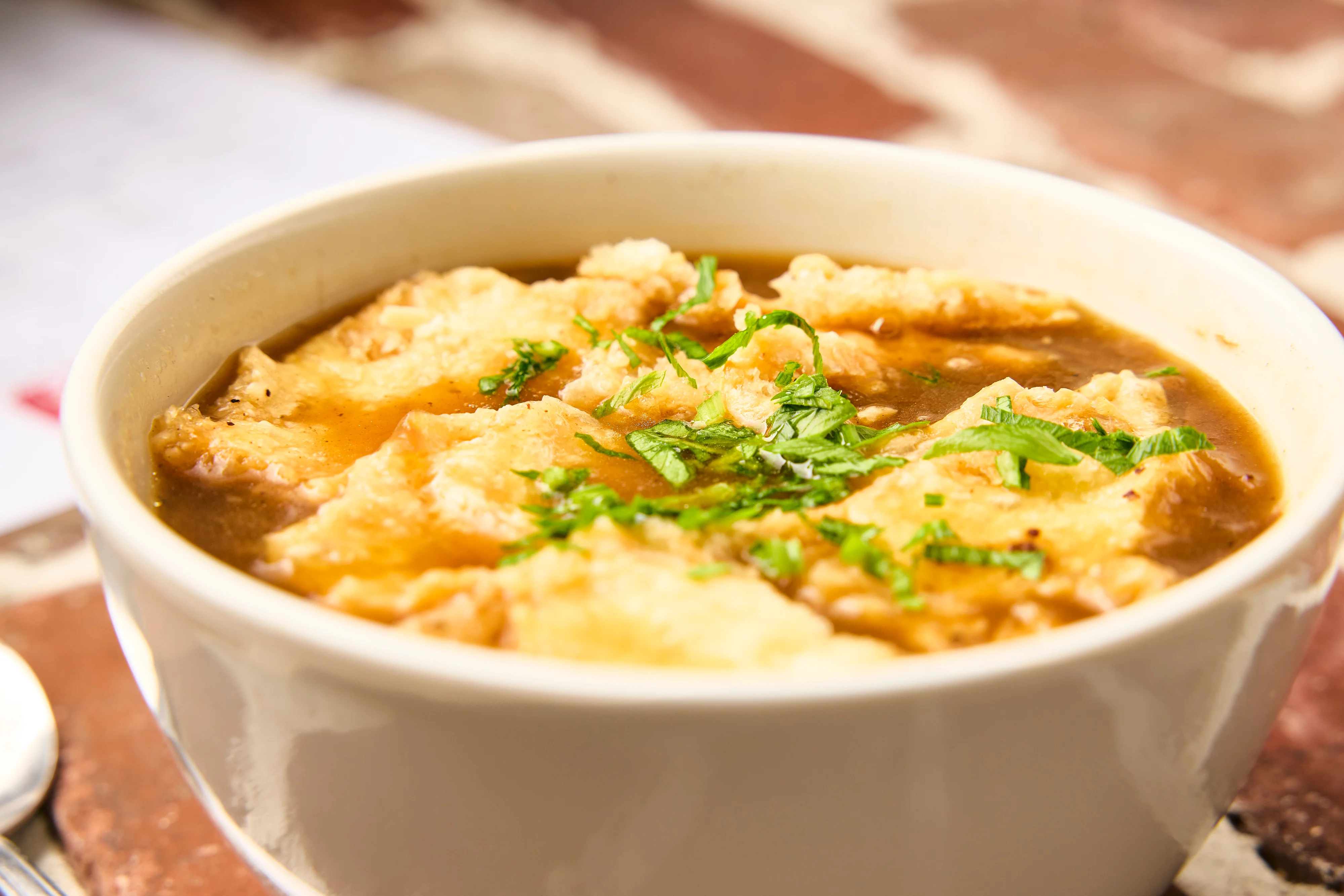 French onion soup topped with melted cheese and herbs