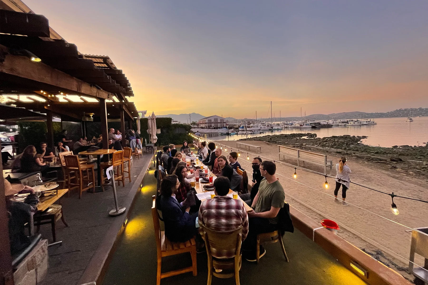 Bar Bocce's green space, people dining outdoors in the evening