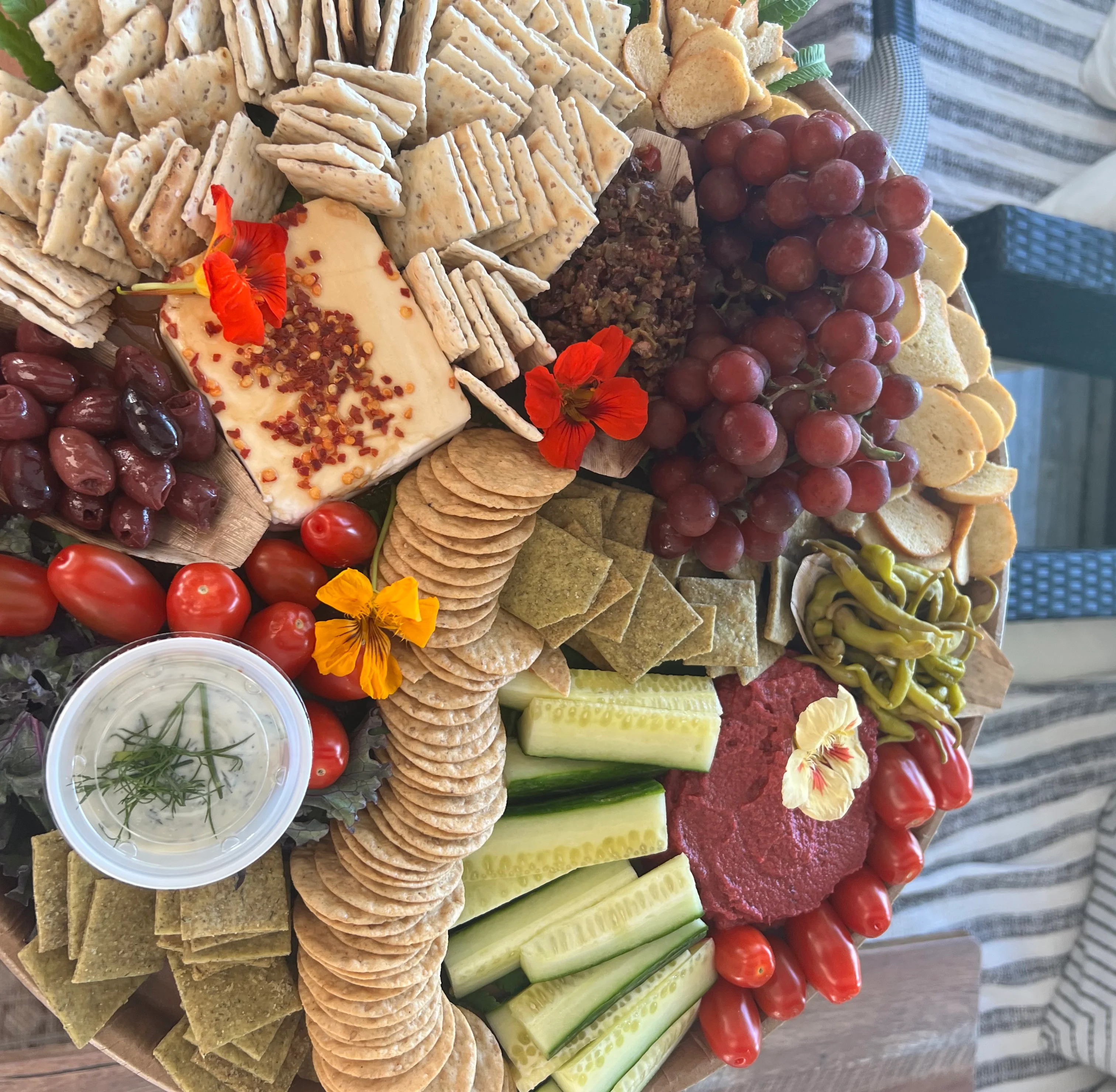 Artisan cheese and charcuterie board with fresh vegetables and dips
