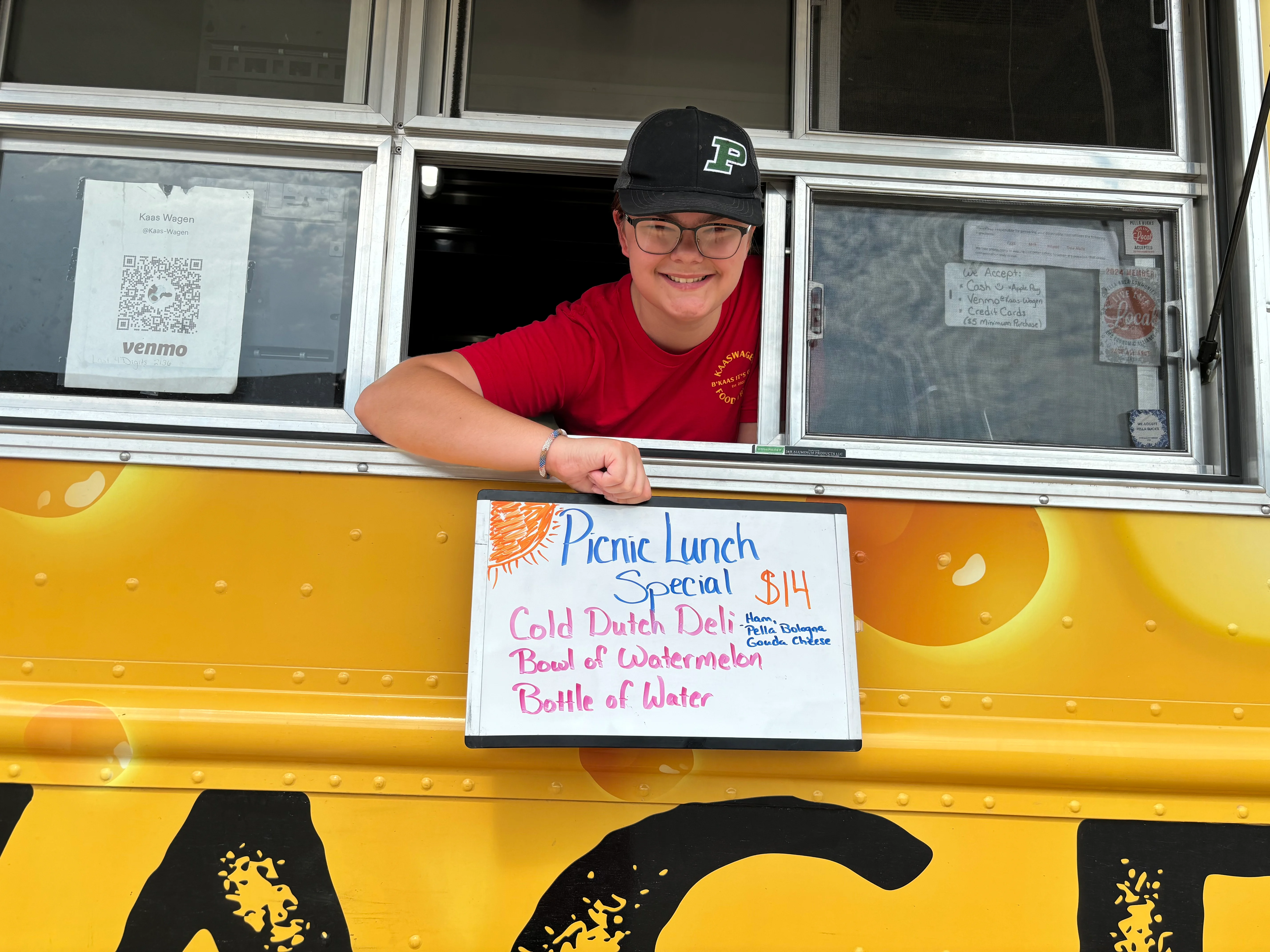 Food truck serving picnic lunch special with deli sandwich and watermelon