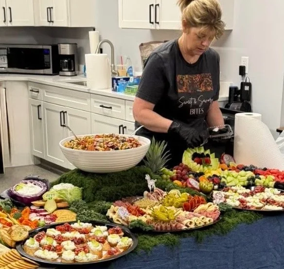 A beautifully arranged buffet table with various appetizers and a salad bowl.