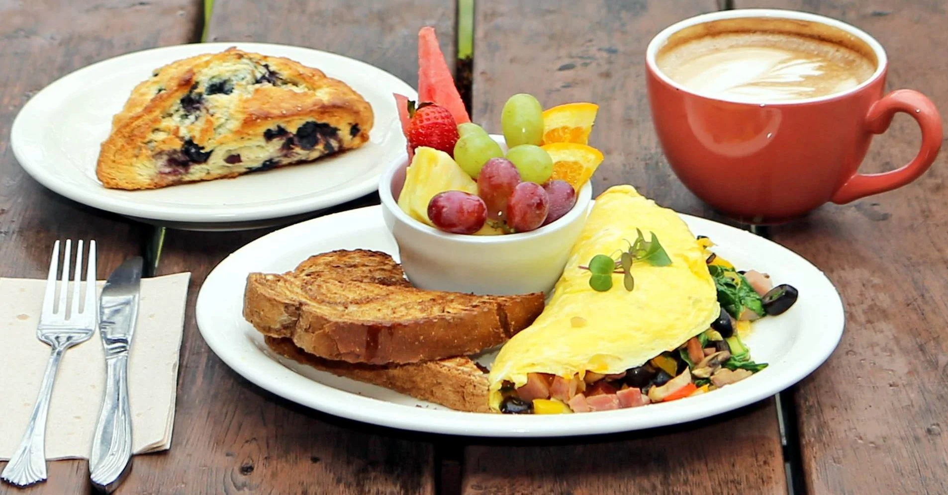 Hearty American breakfast with omelette, toast, fruit, and coffee