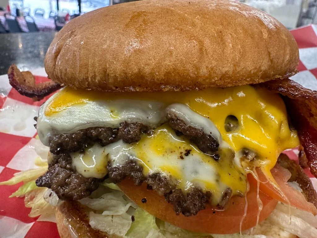 Juicy cheeseburger with bacon and fresh toppings