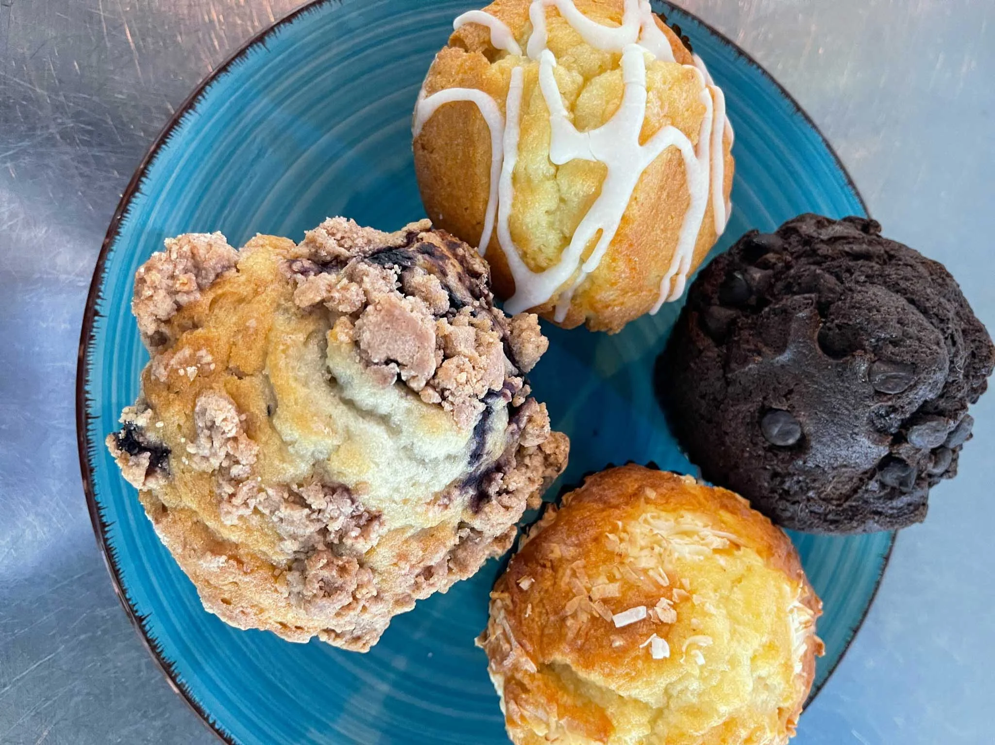 Assorted gourmet muffins on a blue plate