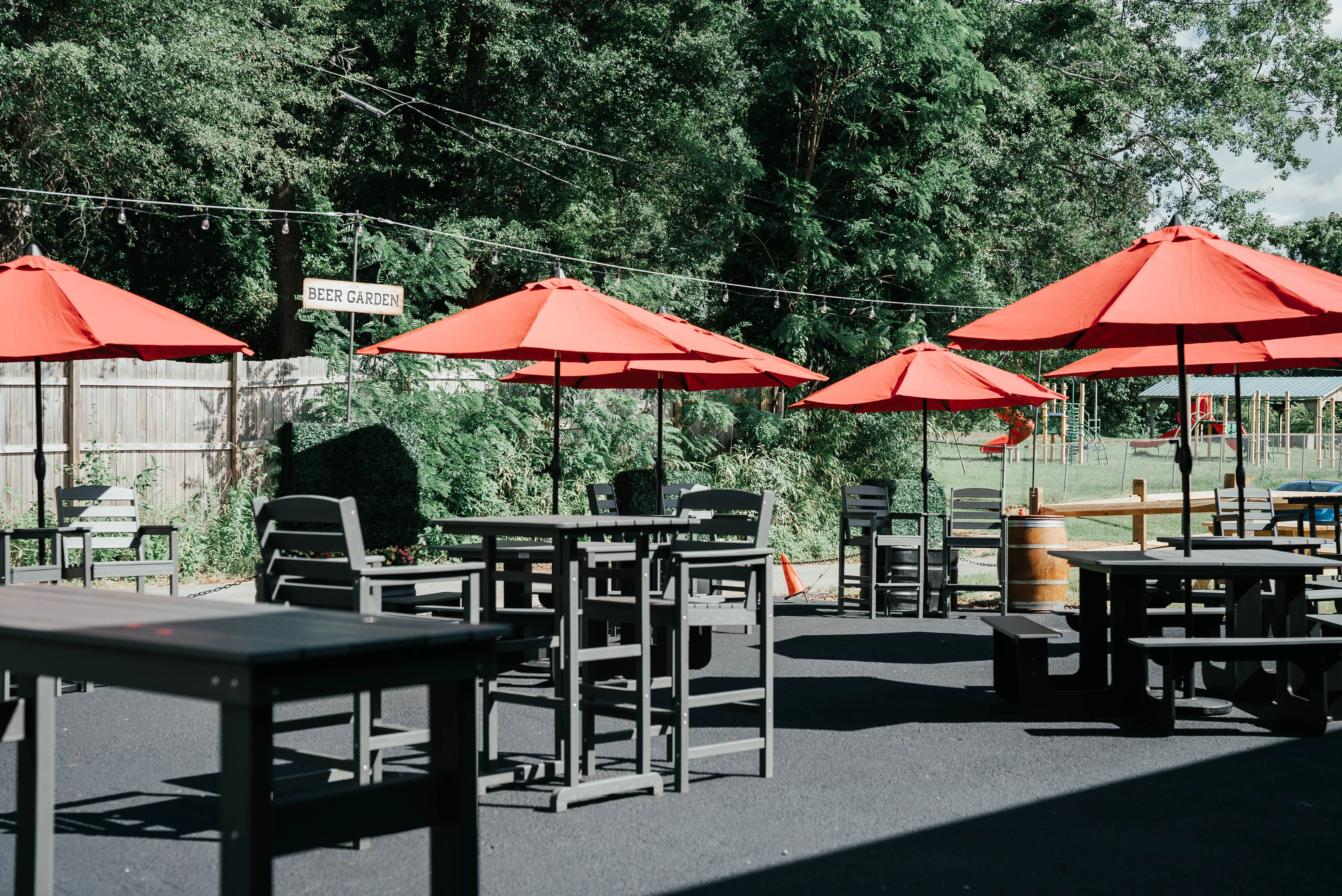 Outdoor beer garden with red umbrellas and seating