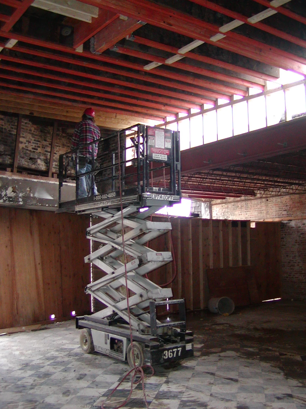 Construction worker on a lift in a renovated restaurant space