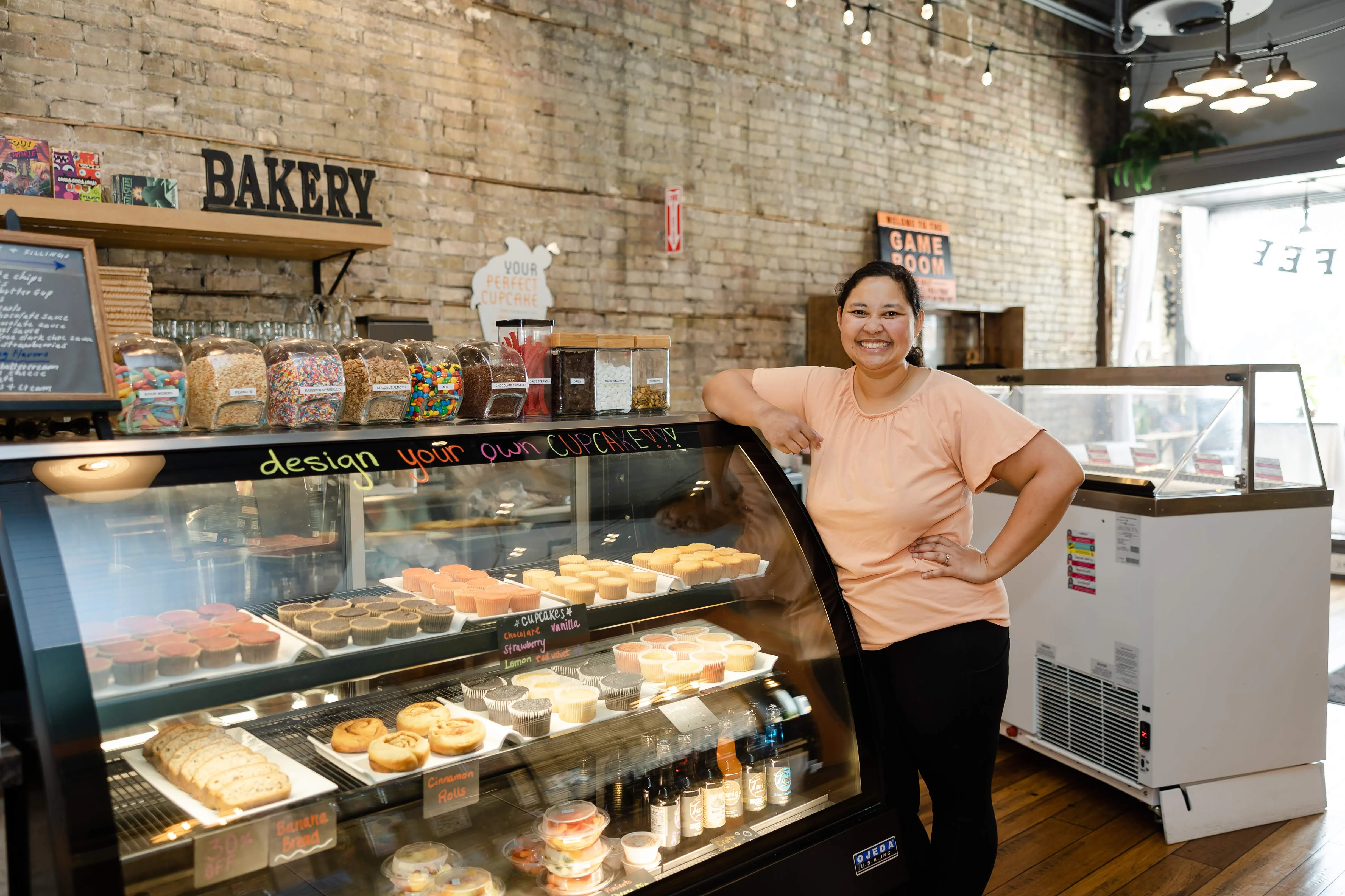 Cozy bakery interior with a cupcake display and friendly staff
