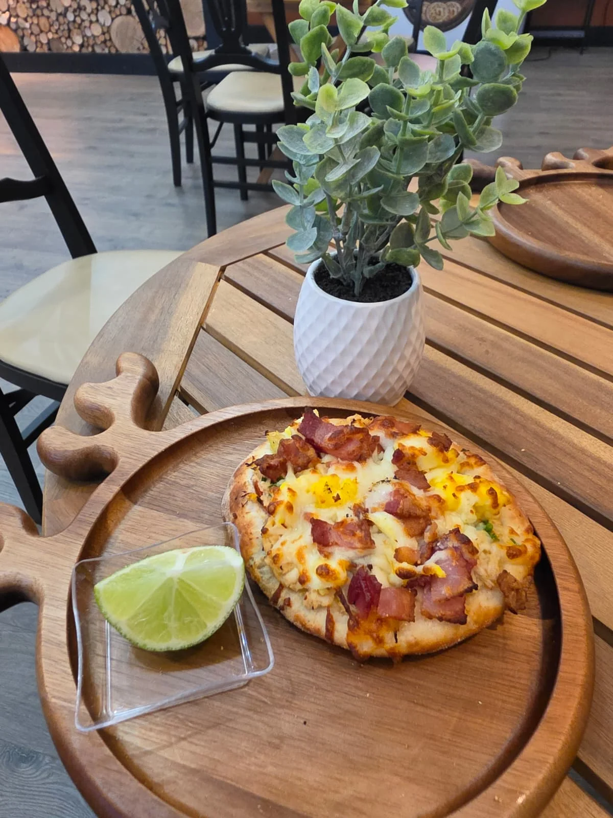 Personal-sized pizza with bacon in a cozy restaurant setting