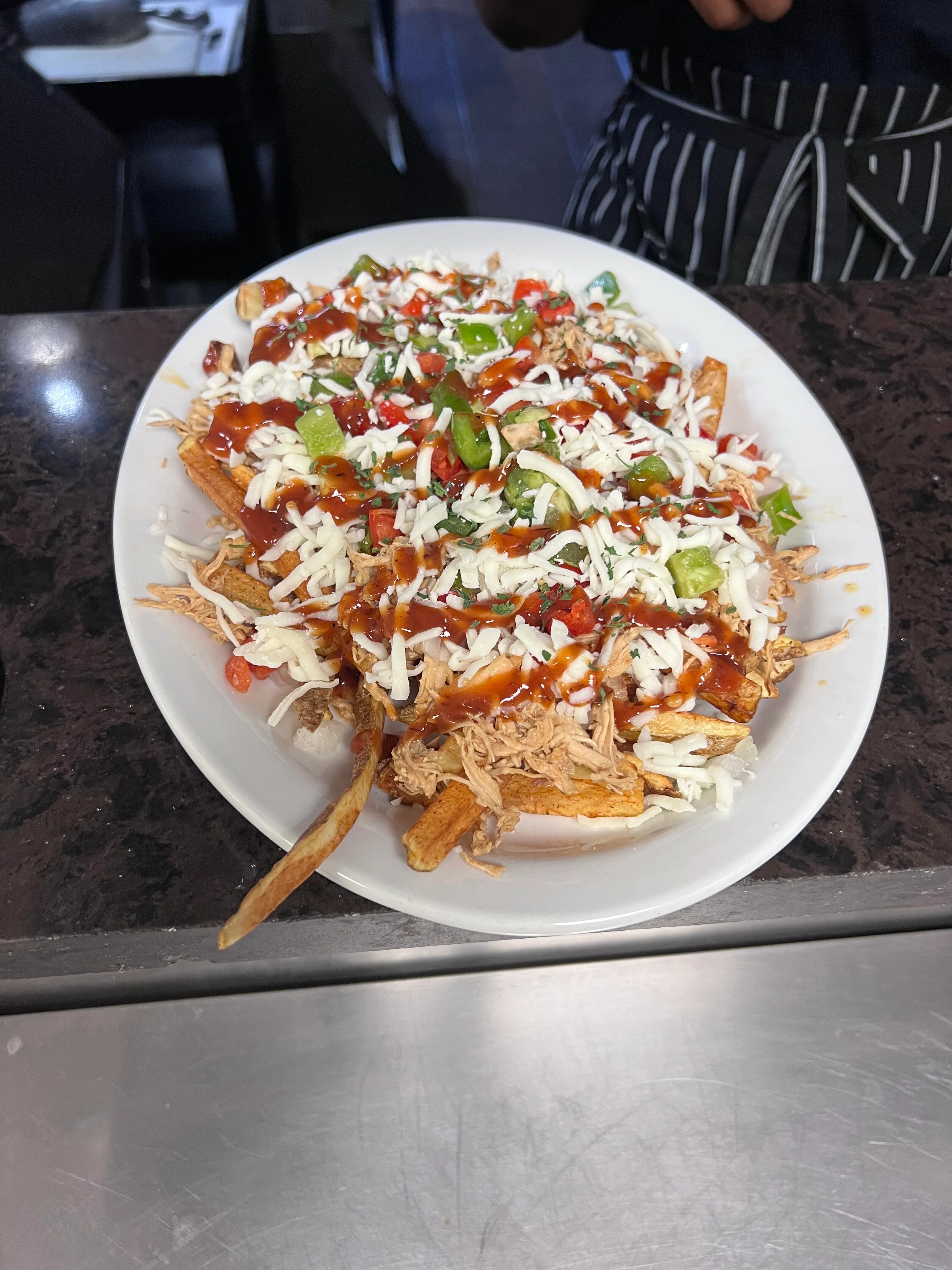 Loaded nachos with shredded chicken and fresh toppings